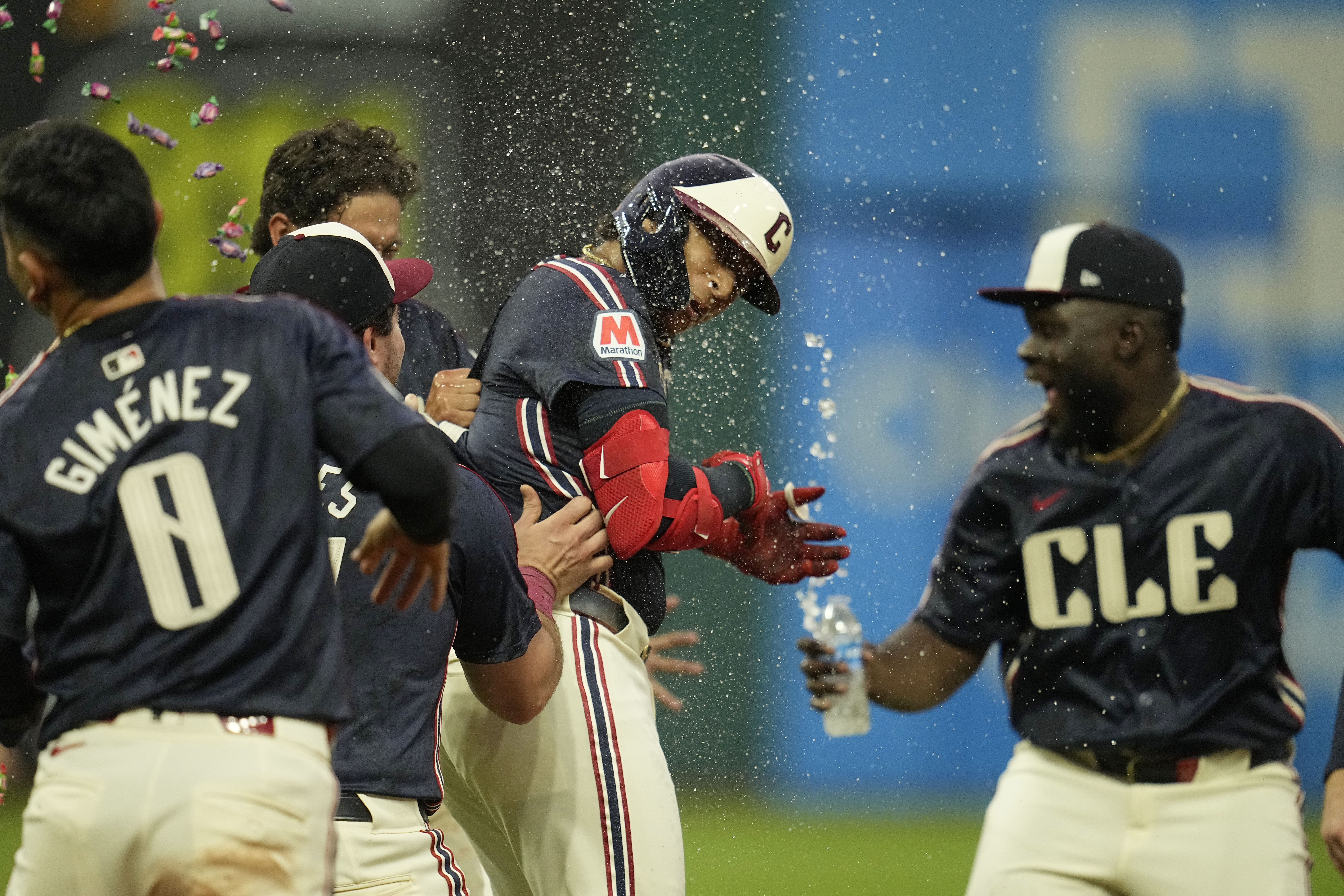 Cleveland Guardians' Bo Naylor, center, is mobbed by teammates after hitting a sacrifice fly to score Andres Gimenez in the ninth inning to defeat the Chicago White Sox in a baseball game Tuesday, July 2, 2024, in Cleveland. 
