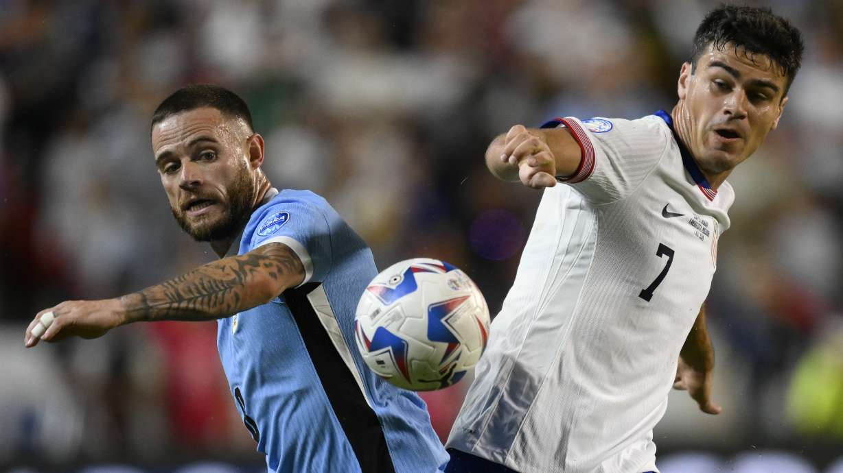 Uruguay's Nahitan Nandez, left, and Gio Reyna of the United States battle for the ball during a Copa America Group C soccer match in Kansas City, Mo., Monday, July 1, 2024.