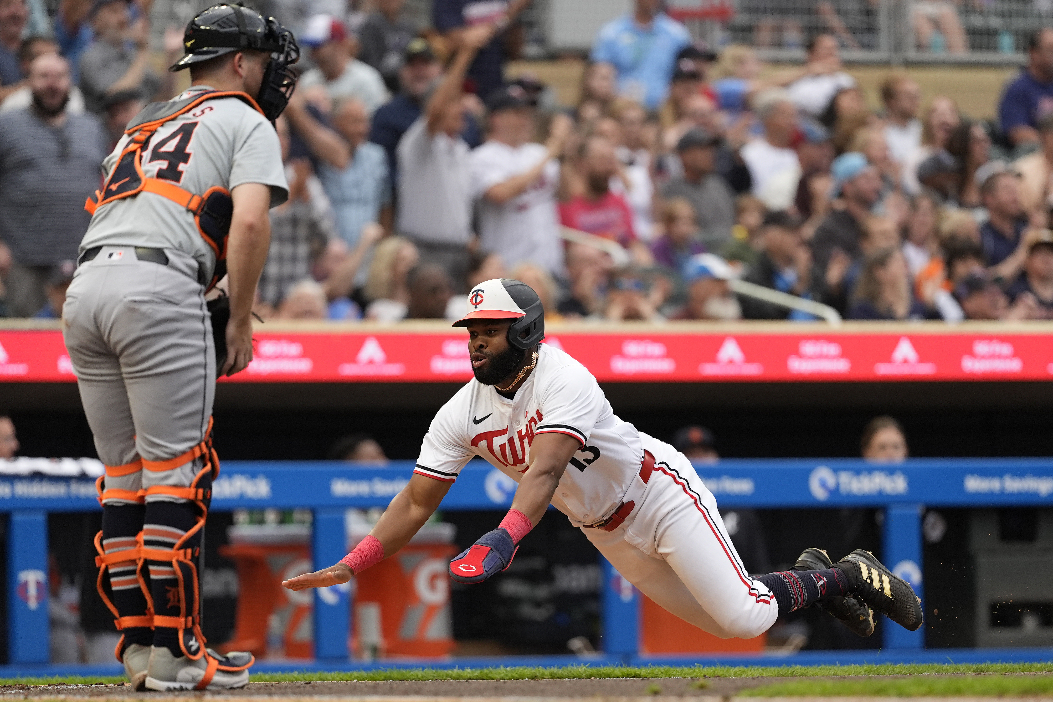 Minnesota Twins' Manuel Margot dives to score off a two-run double during the third inning of a baseball game against the Detroit Tigers, Tuesday, July 2, 2024, in Minneapolis. 