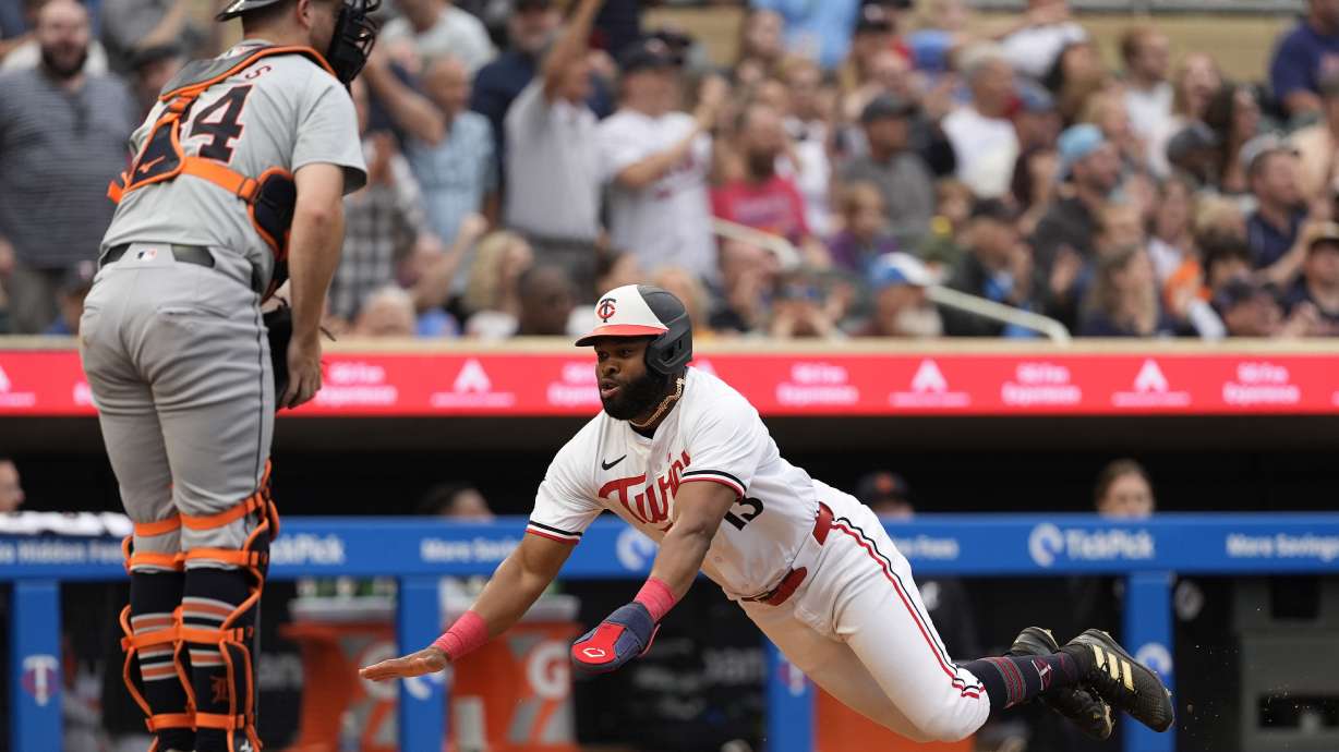 Minnesota Twins' Manuel Margot dives to score off a two-run double during the third inning of a baseball game against the Detroit Tigers, Tuesday, July 2, 2024, in Minneapolis.