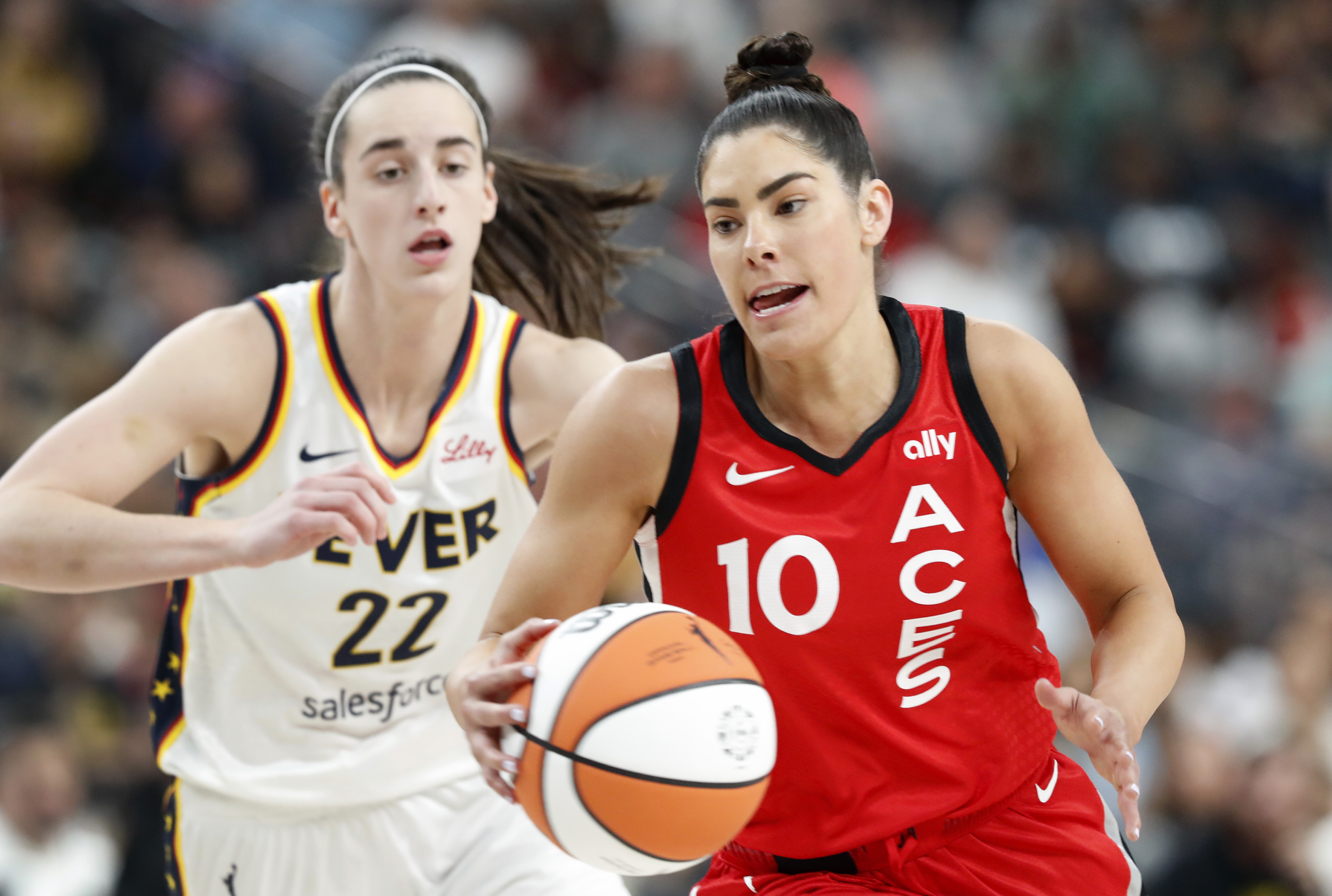 Las Vegas Aces guard Kelsey Plum (10) takes the ball past Indiana Fever guard Caitlin Clark (22) during the first half of an WNBA basketball game Tuesday, July 2, 2024, in Las Vegas.