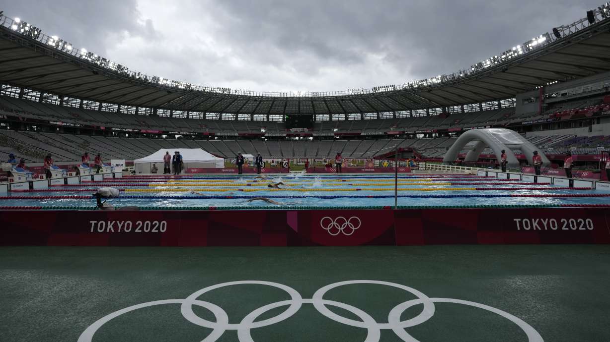 FILE - Athletes compete in the swimming portion of the men's modern pentathlon at the 2020 Summer Olympics, Saturday, Aug. 7, 2021, in Tokyo, Japan. Athletes at the last Summer Olympics remember the unmistakable sadness and longing of competing with nearly no one in the stands, thanks to pandemic-era restrictions in Tokyo three years ago. At the Paris Games, which begin this month, those folks can all join in for the ride, offering something that was missing the last time around on the big stage: a support system that can help improve results, help get through the tough moments and help celebrate the best ones.