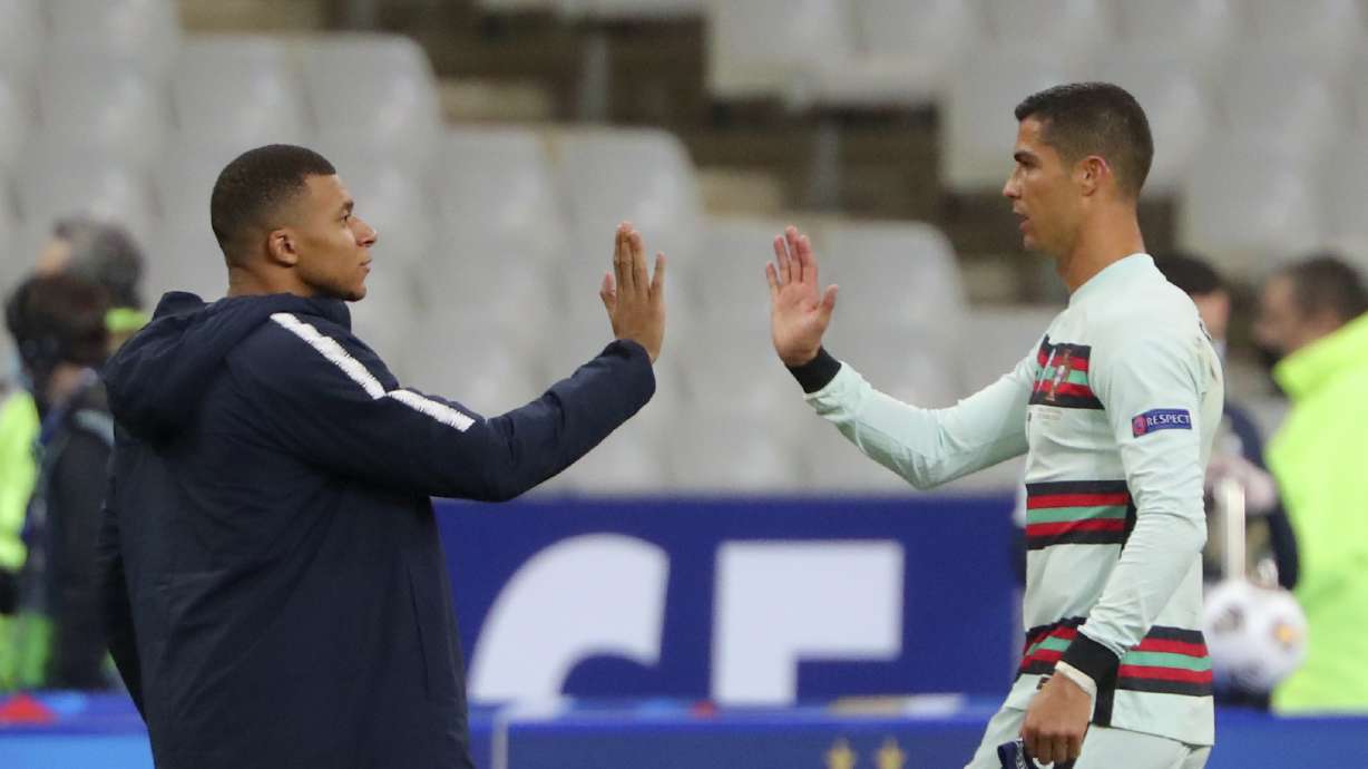 FILE - In this Sunday, Oct. 11, 2020 file photo France's Kylian Mbappe and Portugal's Cristiano Ronaldo, right, greet each other before the Nations League soccer match between France and Portugal at the Stade de France in Saint-Denis, north of Paris, France. Cristiano Ronaldo vs. Kylian Mbappe is not just a clash of soccer icons but a clash of generations. They’ll go head to head when Portugal plays France in the Euro 2024 quarterfinals on Friday and their heavyweight meeting just got a little bit bigger after Ronaldo said this would be his last European Championship.