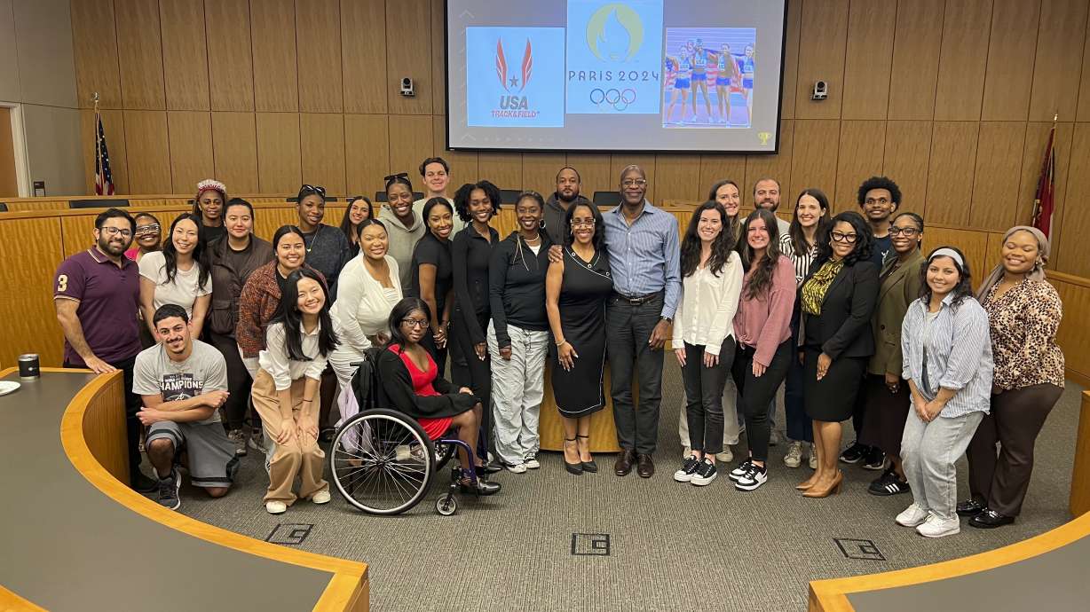 This image released by Georgia State University shows law professor Moraima “Mo” Ivory, center, left, posing with Olympian Edwin Moses, center, right, and her Legal Life class at Georgia State University in Atlanta. Ivory is known for bringing celebrities like Steve Harvey and Ludacris into her law class. But now she's taking her Atlanta law students on a free trip to the Paris Olympics this summer in hopes of creating real-life teachable moments.