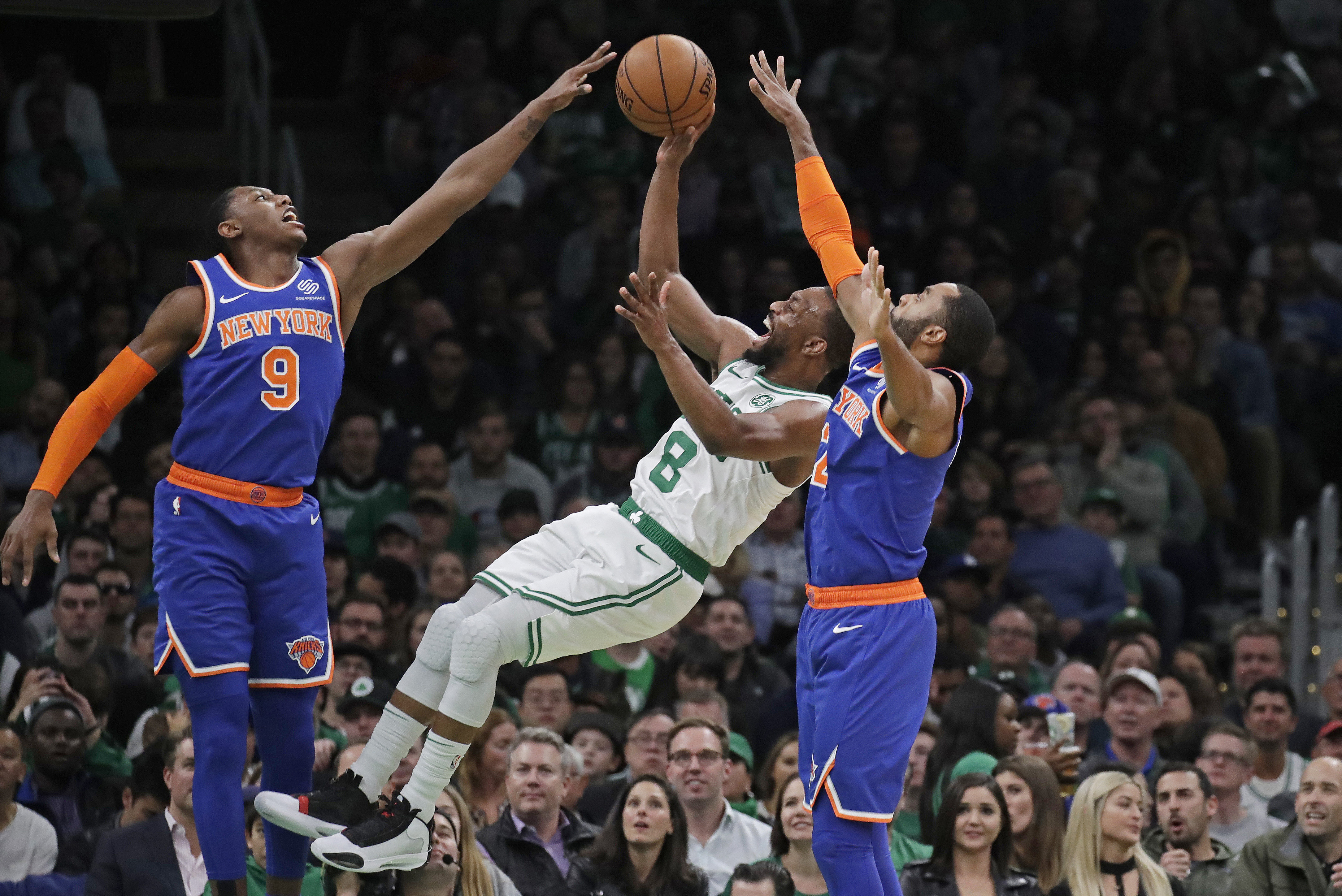 FILE - Boston Celtics guard Kemba Walker (8) shoots between New York Knicks guard RJ Barrett (9) and guard Wayne Ellington during the second half of an NBA basketball game Friday, Nov. 1, 2019, in Boston. Kemba Walker, a four-time All-Star guard, says he’s retiring from basketball. Walker, 34, wasn’t in the NBA this past season but did play in the EuroLeague with AS Monaco. He announced his decision Tuesday, July 2, 2024, on social media. 