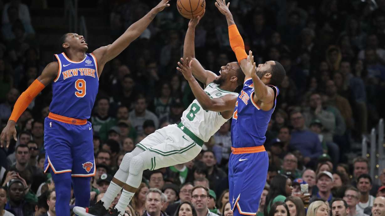 FILE - Boston Celtics guard Kemba Walker (8) shoots between New York Knicks guard RJ Barrett (9) and guard Wayne Ellington during the second half of an NBA basketball game Friday, Nov. 1, 2019, in Boston. Kemba Walker, a four-time All-Star guard, says he’s retiring from basketball. Walker, 34, wasn’t in the NBA this past season but did play in the EuroLeague with AS Monaco. He announced his decision Tuesday, July 2, 2024, on social media.