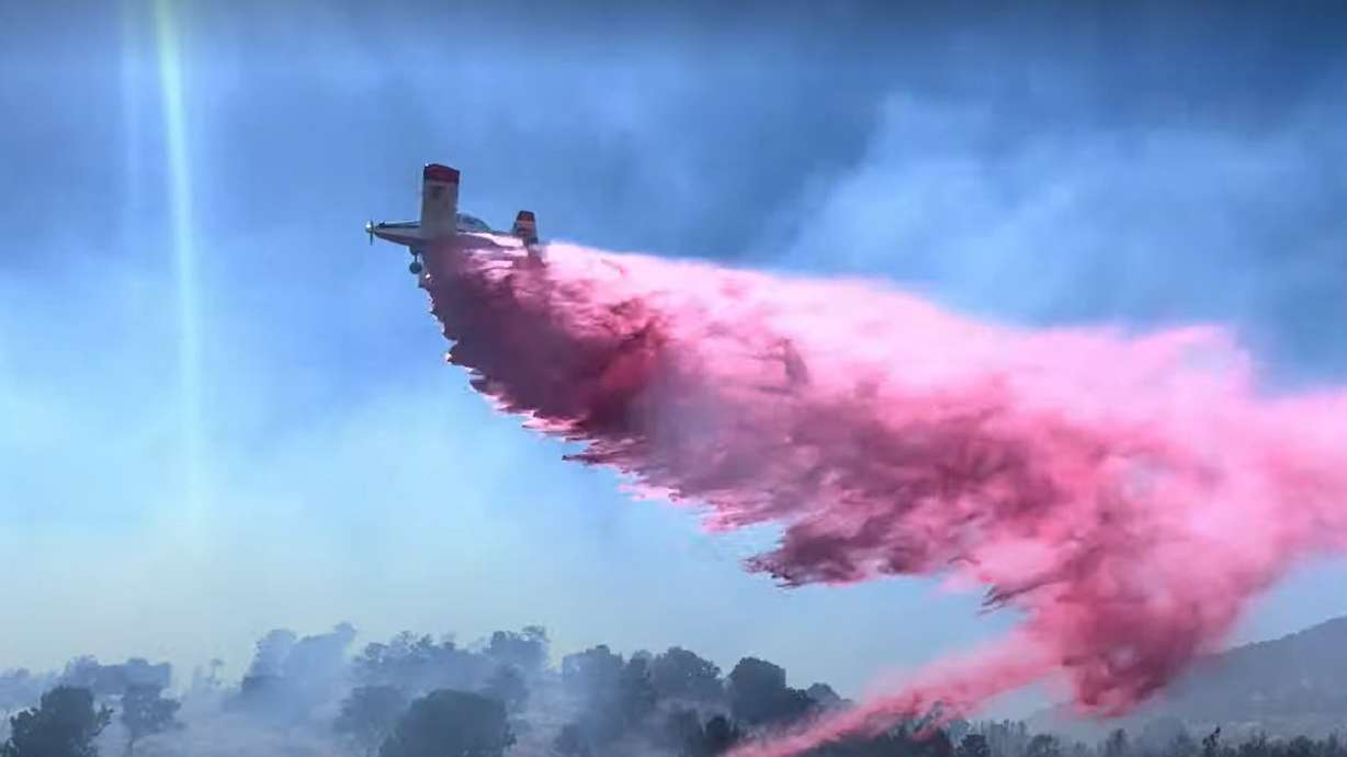 A plane dumps fire retardant onto the Central Fire in Washington County on Sunday. The fire is one of the nearly 300 human-caused wildfires that have started so far this year, accounting for over 70% of this year's fires.