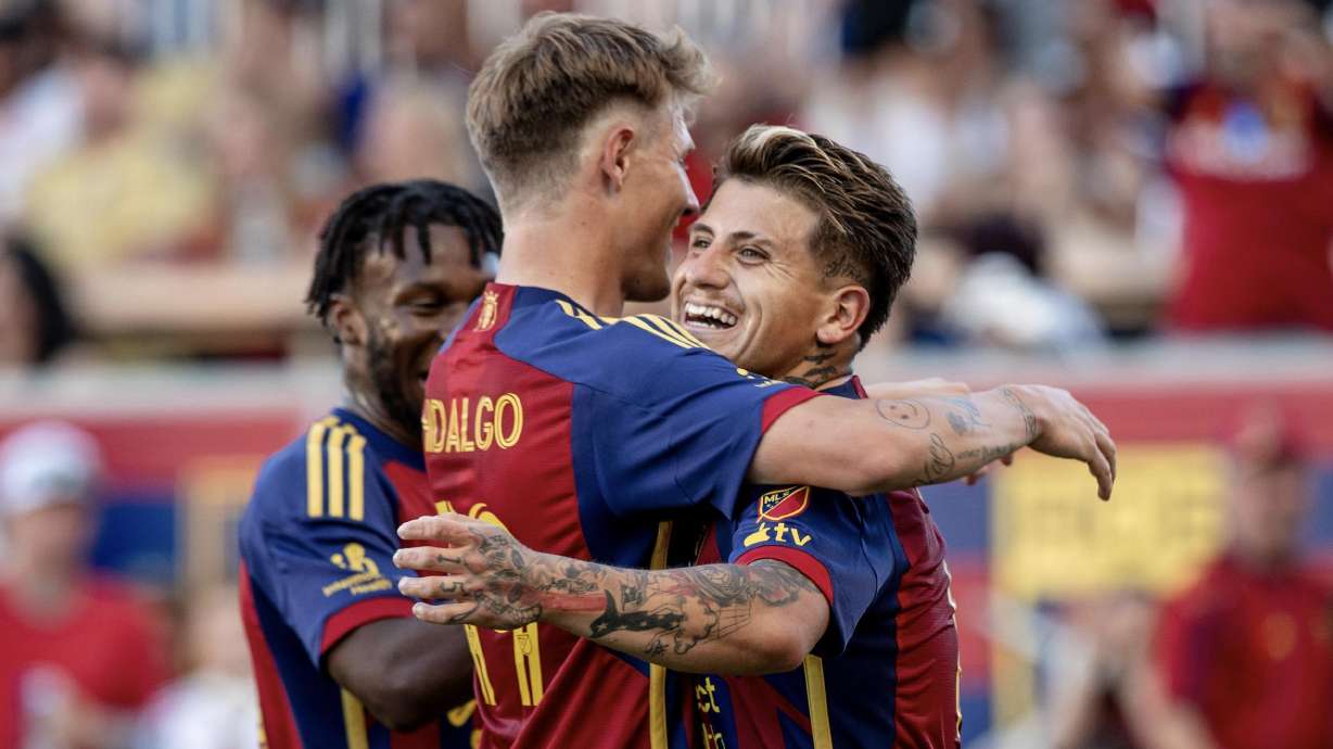 Bode Hidalgo, middle, and Diego Luna, right, hug after Luna's goal against Houston at America First Field.
