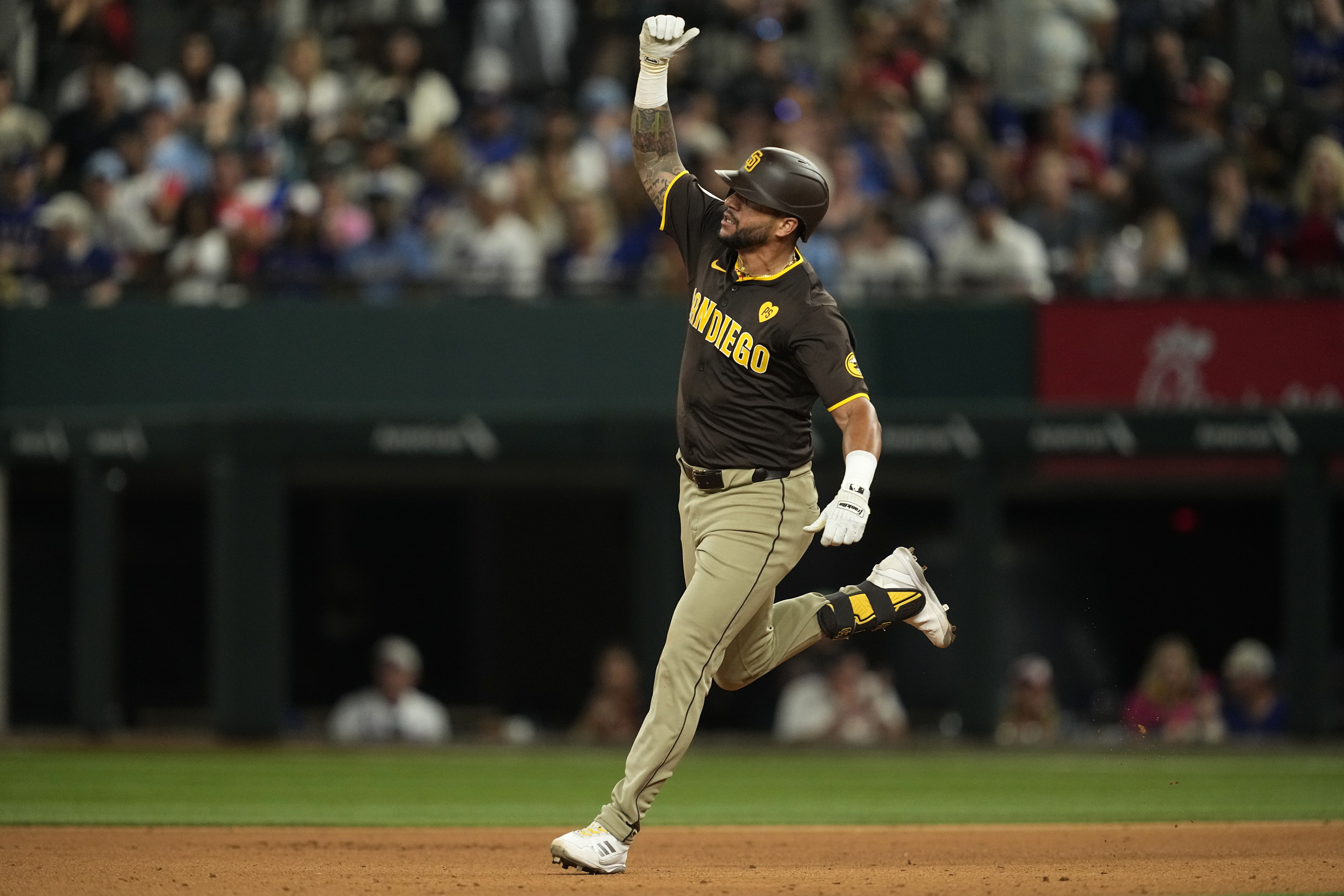 San Diego Padres' David Peralta celebrates his two-run home run against the Texas Rangers in the seventh inning of a baseball game Wednesday, July 3, 2024 in Arlington, Texas. Donovan Solano also scored on the shot.