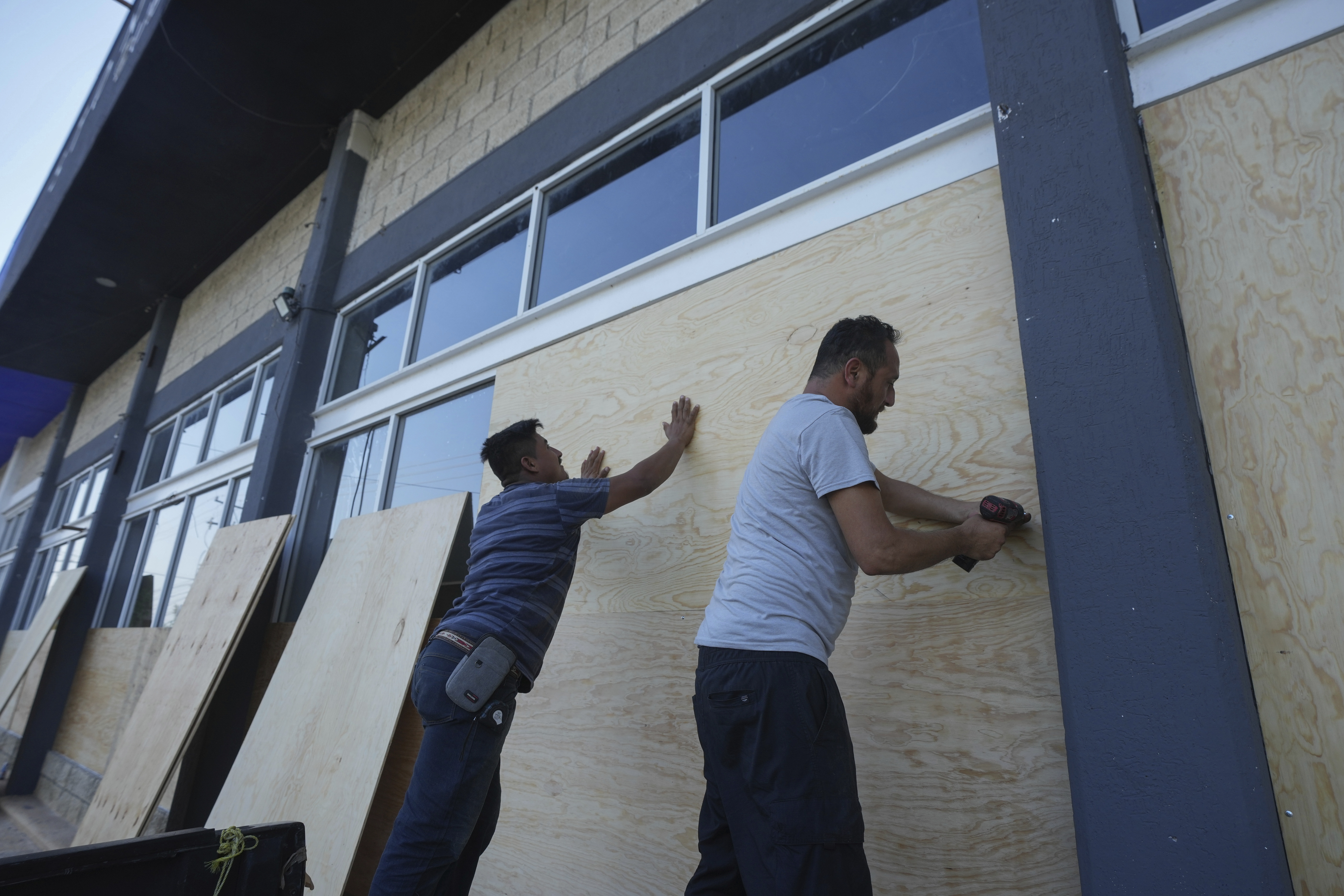 Furniture store employees board up windows for protection ahead of Hurricane Beryl's expected arrival, in Playa del Carmen, Mexico, Wednesday.