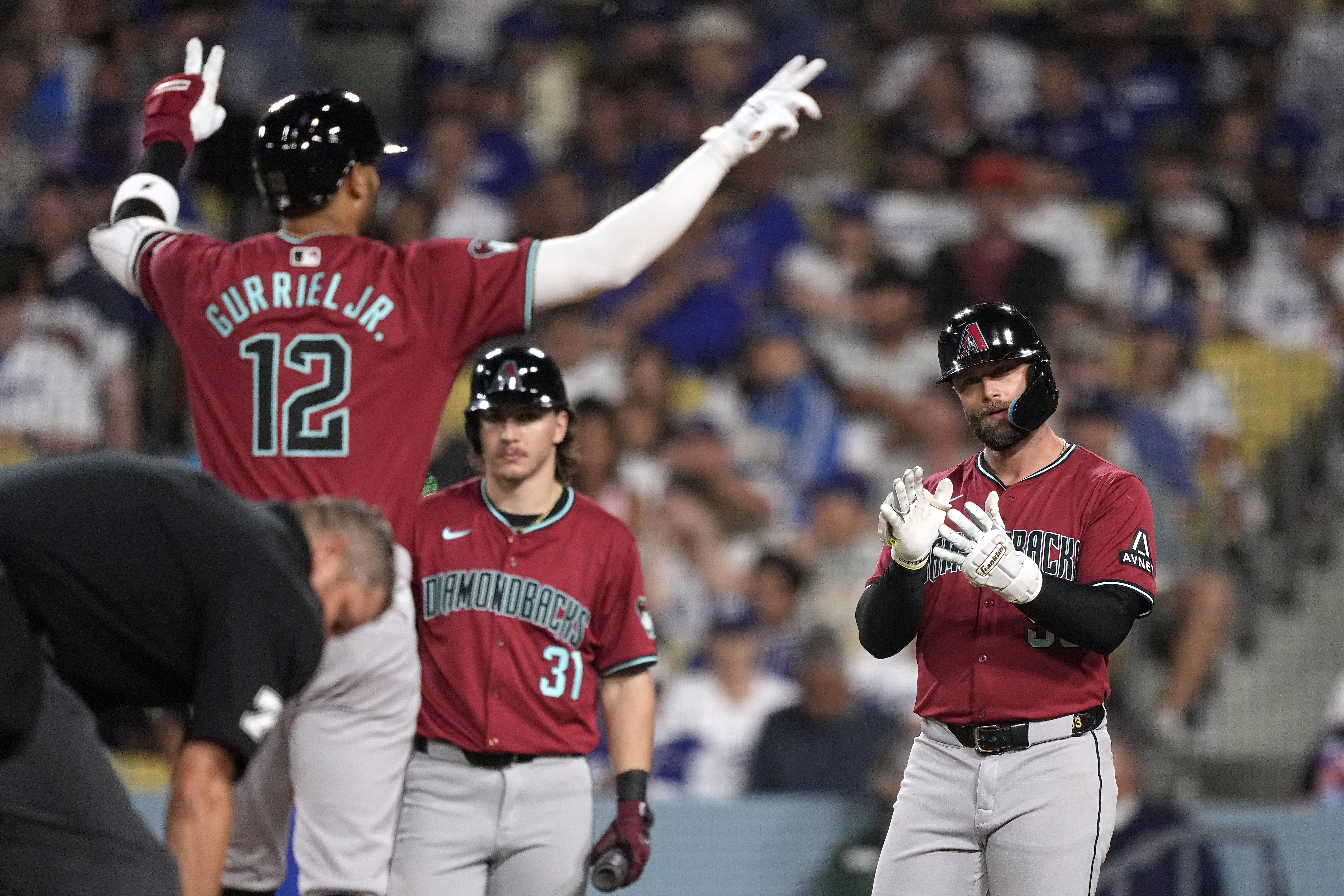 Arizona Diamondbacks' Lourdes Gurriel Jr., left, and Christian Walker, right, celebrate as Jake McCarthy watches after Gurriel Jr. hit a two-run home run during the sixth inning of a baseball game against the Los Angeles Dodgers Wednesday, July 3, 2024, in Los Angeles. 