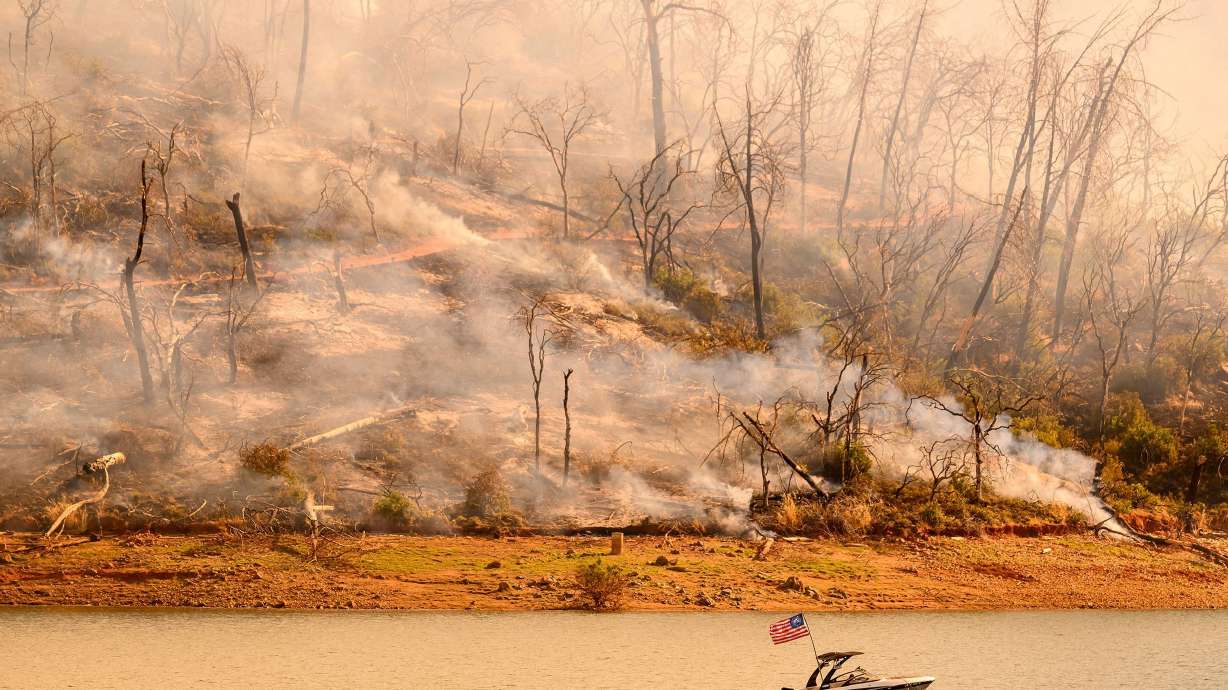 A boat moves along Lake Oroville as the Thompson Fire continues to burn in Oroville, California, on July 3.