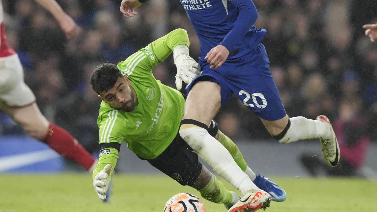 FILE - Chelsea's Cole Palmer goes with the ball past Arsenal's goalkeeper David Raya in an unsuccessful attempt to score during the English Premier League soccer match between Chelsea and Arsenal at Stamford Bridge stadium in London, England, Saturday, Oct. 21, 2023. Premier League runner-up Arsenal signed goalkeeper David Raya on a long-term contract Thursday, July 4, 2024 after he did well on loan from Brentford last season.