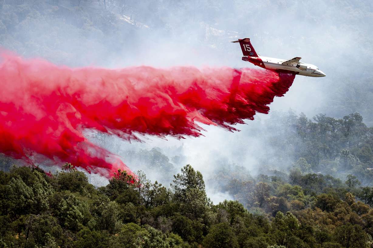 An air tanker drops retardant while trying to stop the Thompson Fire from spreading in Oroville, Calif., Wednesday. An extended heat wave blanketing Northern California has resulted in red flag fire warnings and power shutoffs.