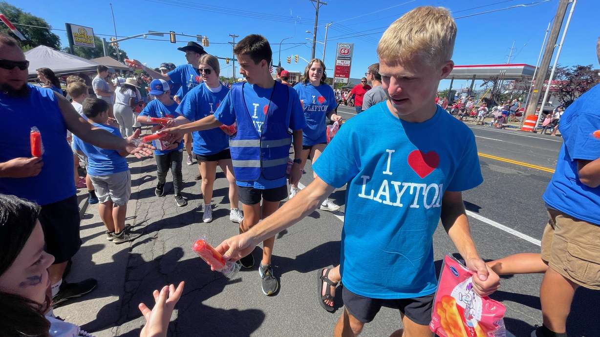 Marchers in the Liberty Days parade in Layton on Thursday, pass out frozen treats to those lining the parade route.