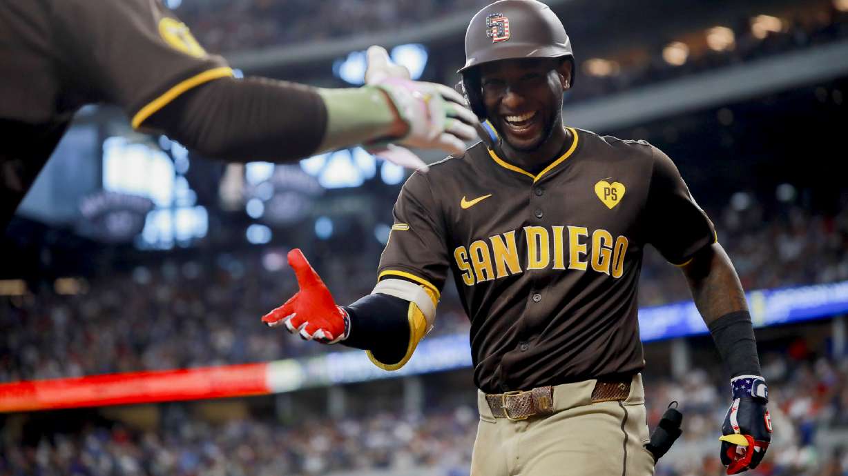 San Diego Padres' Jurickson Profar, right, celebrates hitting a home run with Manny Machado during the sixth inning of a baseball game against the Texas Rangers, Thursday, July 4, 2024, in Arlington, Texas.