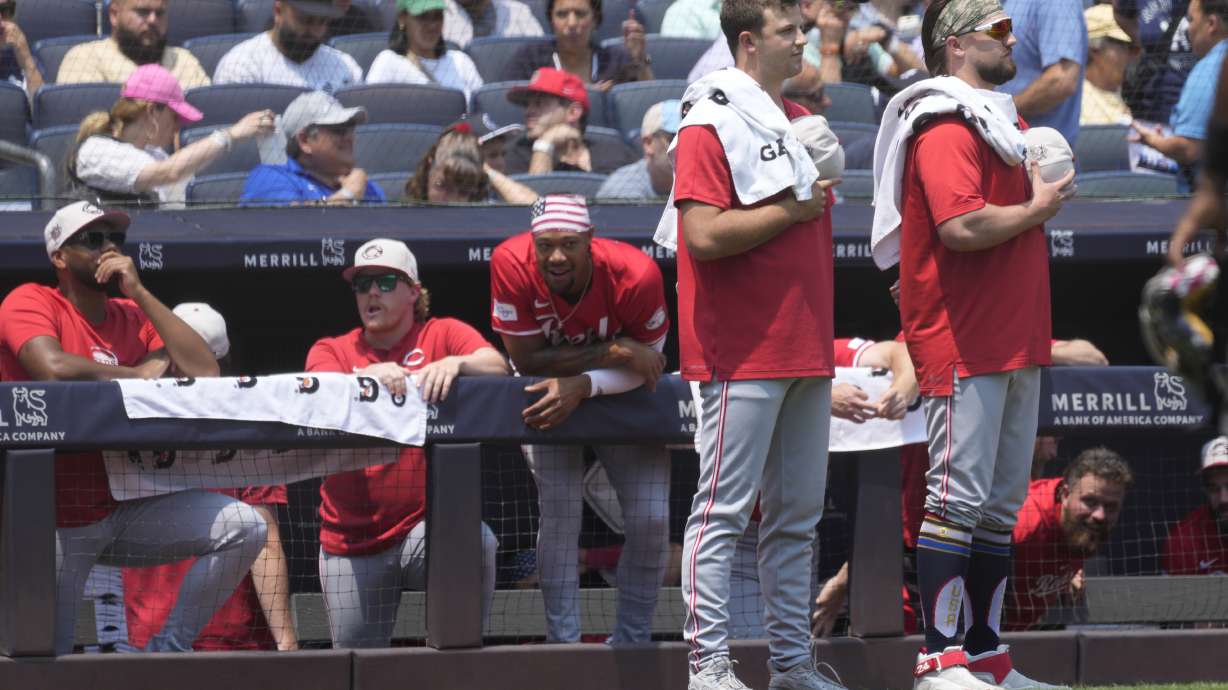 Cincinnati Reds' Carson Spiers, left, and Graham Ashcraft, right, stand after the national anthem before the first inning of a baseball game against the New York Yankees, Thursday, July 4, 2024, in New York.
