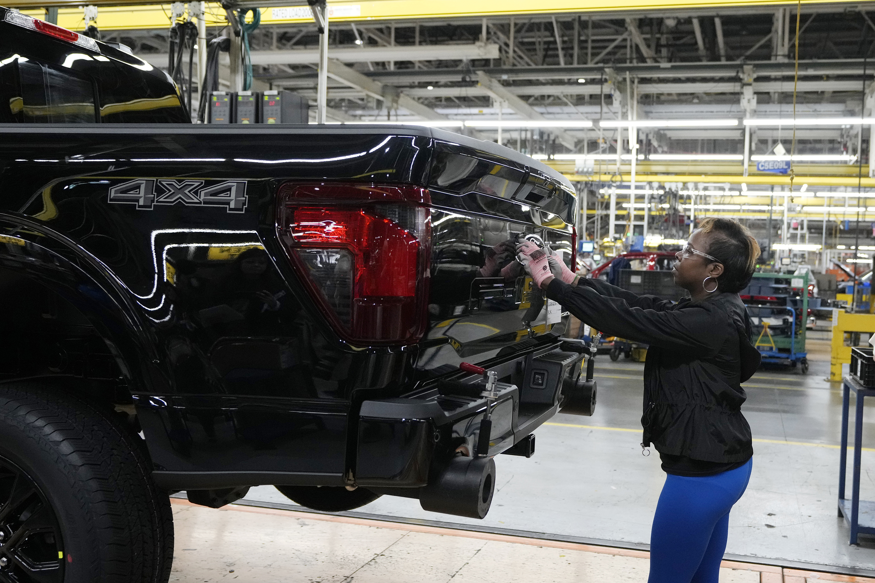 Assembly line worker Lashunta Harris applies the Ford logo on a 2024 Ford F-150 truck being assembled at the Dearborn Truck Plant, April 11 in Dearborn, Mich. On Friday the U.S. government issued its June jobs report. 
