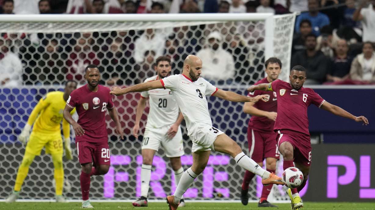 FILE - Palestine's Mohammed Rashid (3) and Qatar's Abdel Aziz Hatim compete for the ball during the Asian Cup round of 16 soccer match between Qatar and Palestine at Al Bayt Stadium in Al Khor, Qatar, Monday, Jan. 29, 2024. Rashid once worked as a forklift driver in a Chicago warehouse
