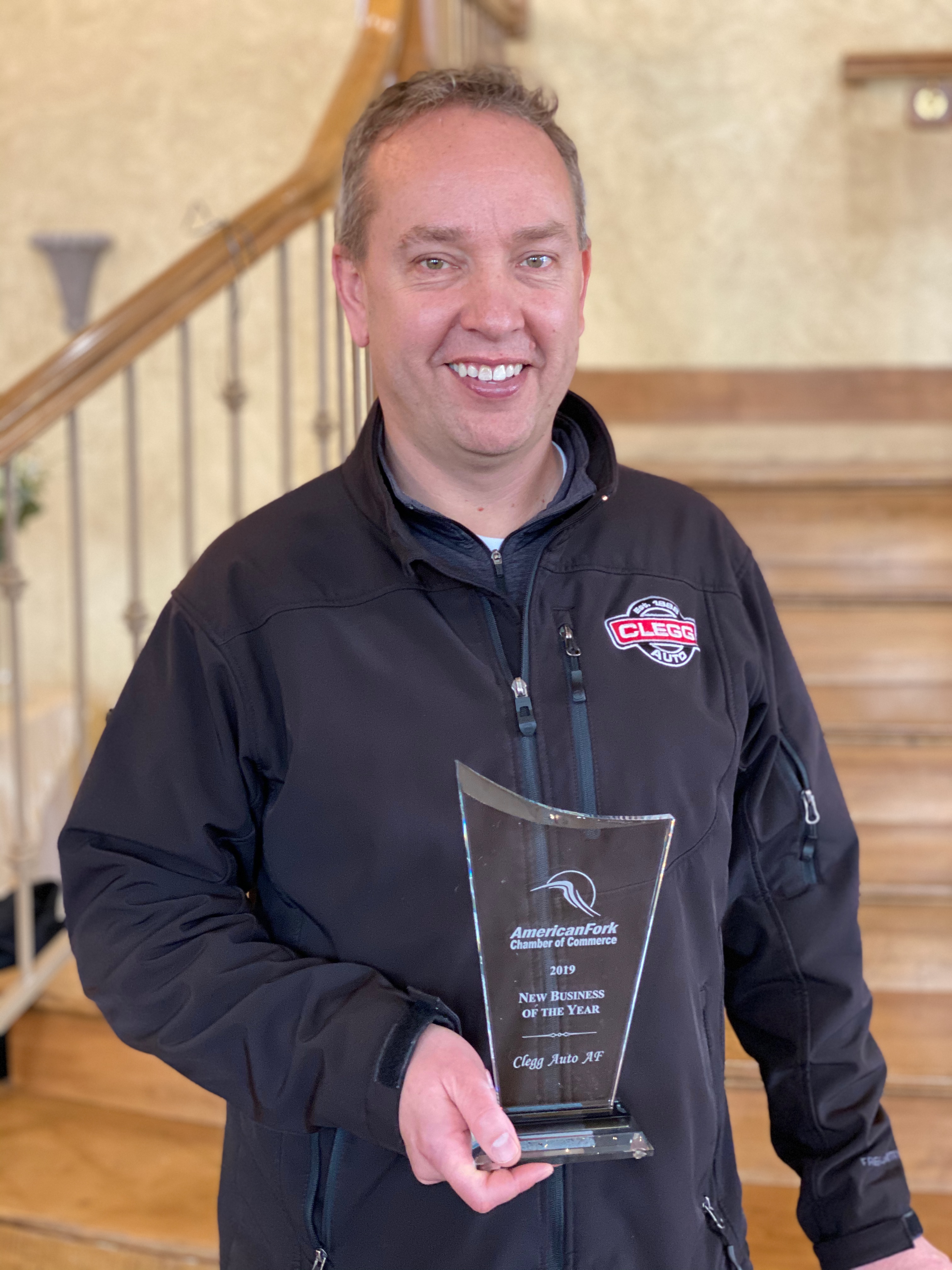 Kevin Clegg, CEO of Clegg Auto, poses with the American Fork Chamber of Commerce 2019 New Business of the Year award.