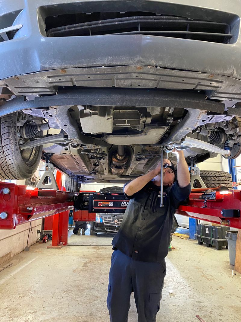 A mechanic works on the undercarriage of a vehicle at one of Clegg Auto's locations.