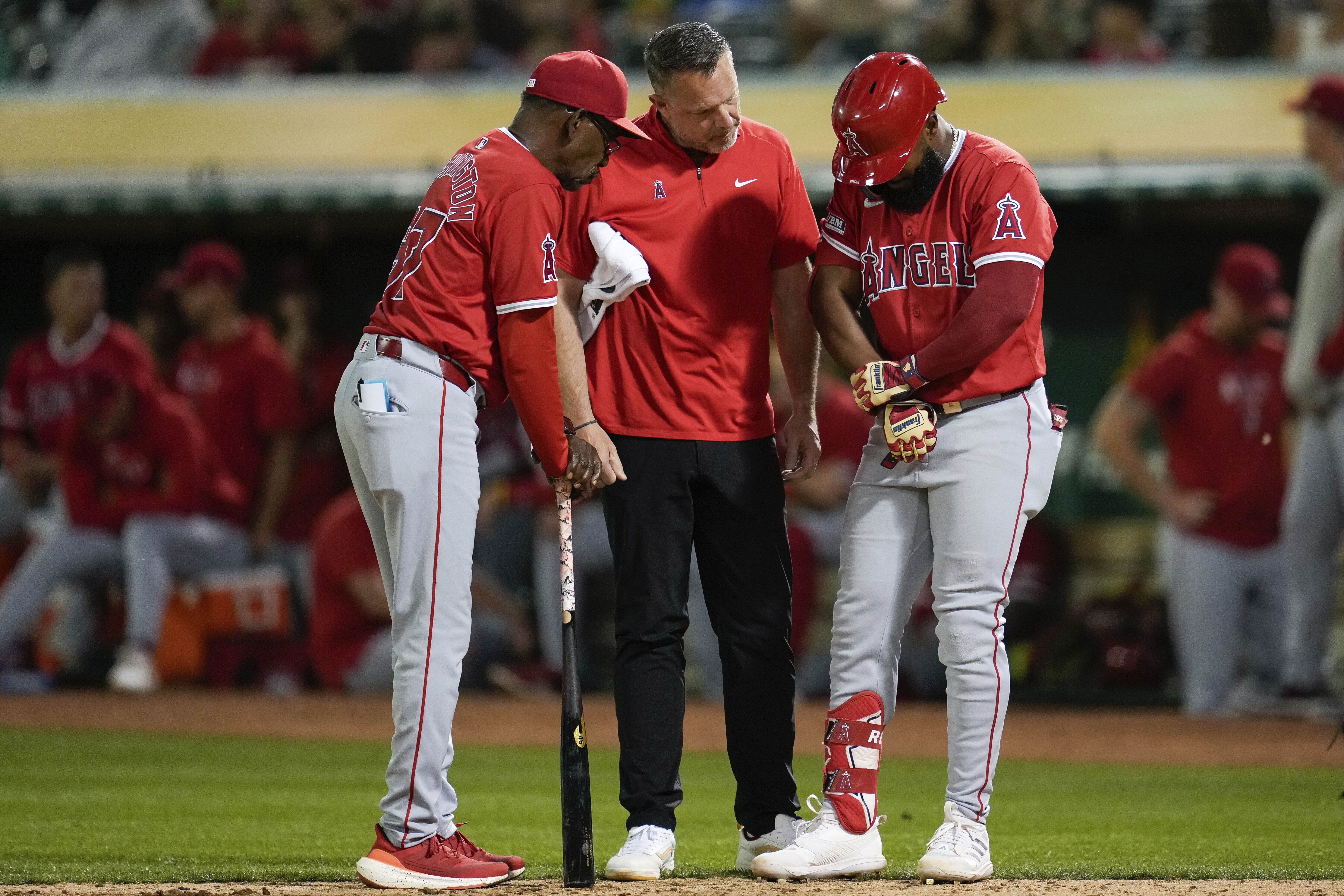 Los Angeles Angels' Luis Rengifo, right, holds his arm during the ninth inning of a baseball game against the Oakland Athletics, Wednesday, July 3, 2024, in Oakland, Calif. Rengifo left the game with an injury. 