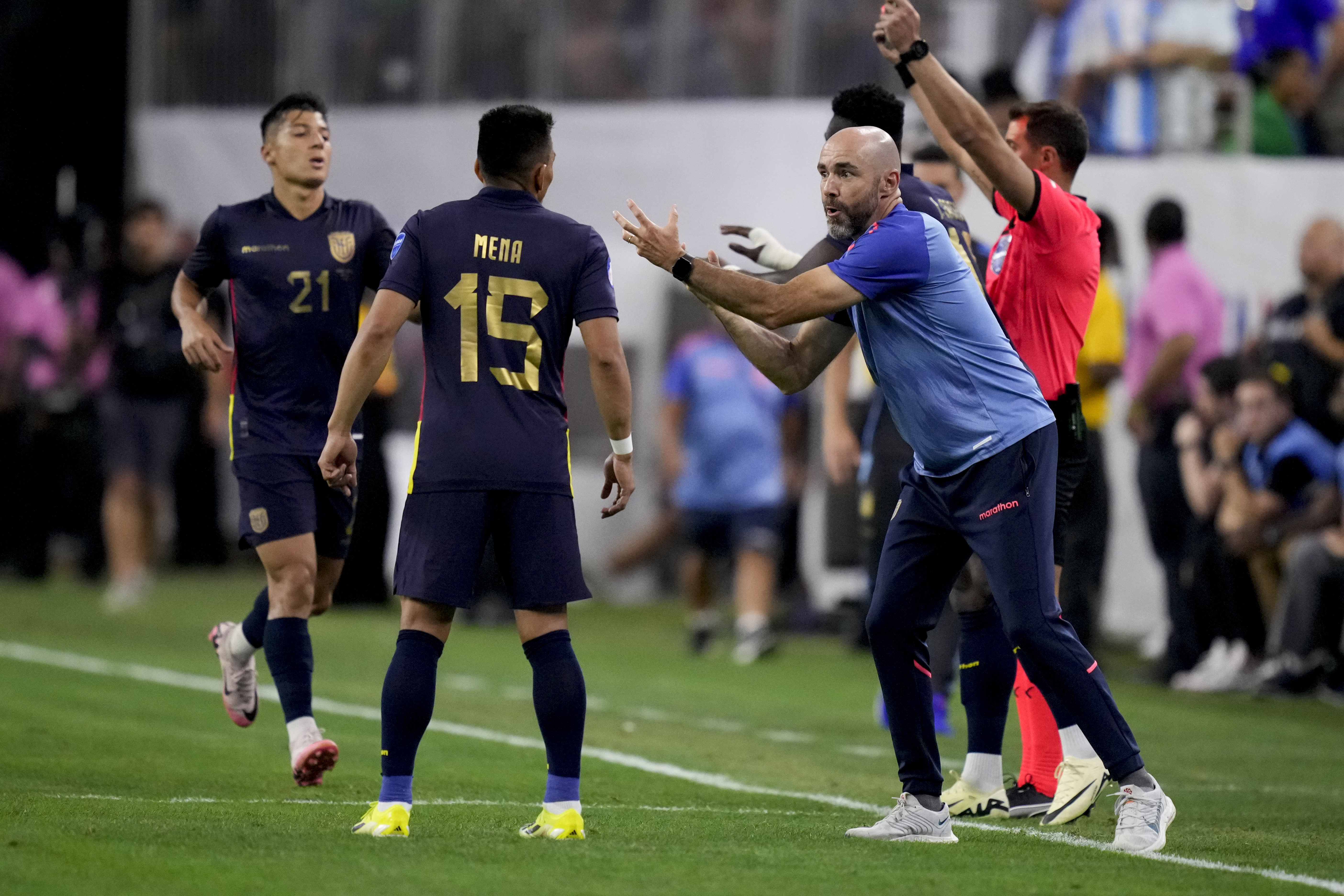 Ecuador's coach Felix Sanchez, right, talks to his player Angel Mena during a Copa America quarterfinal soccer match against Argentina in Houston, Thursday, July 4, 2024. 