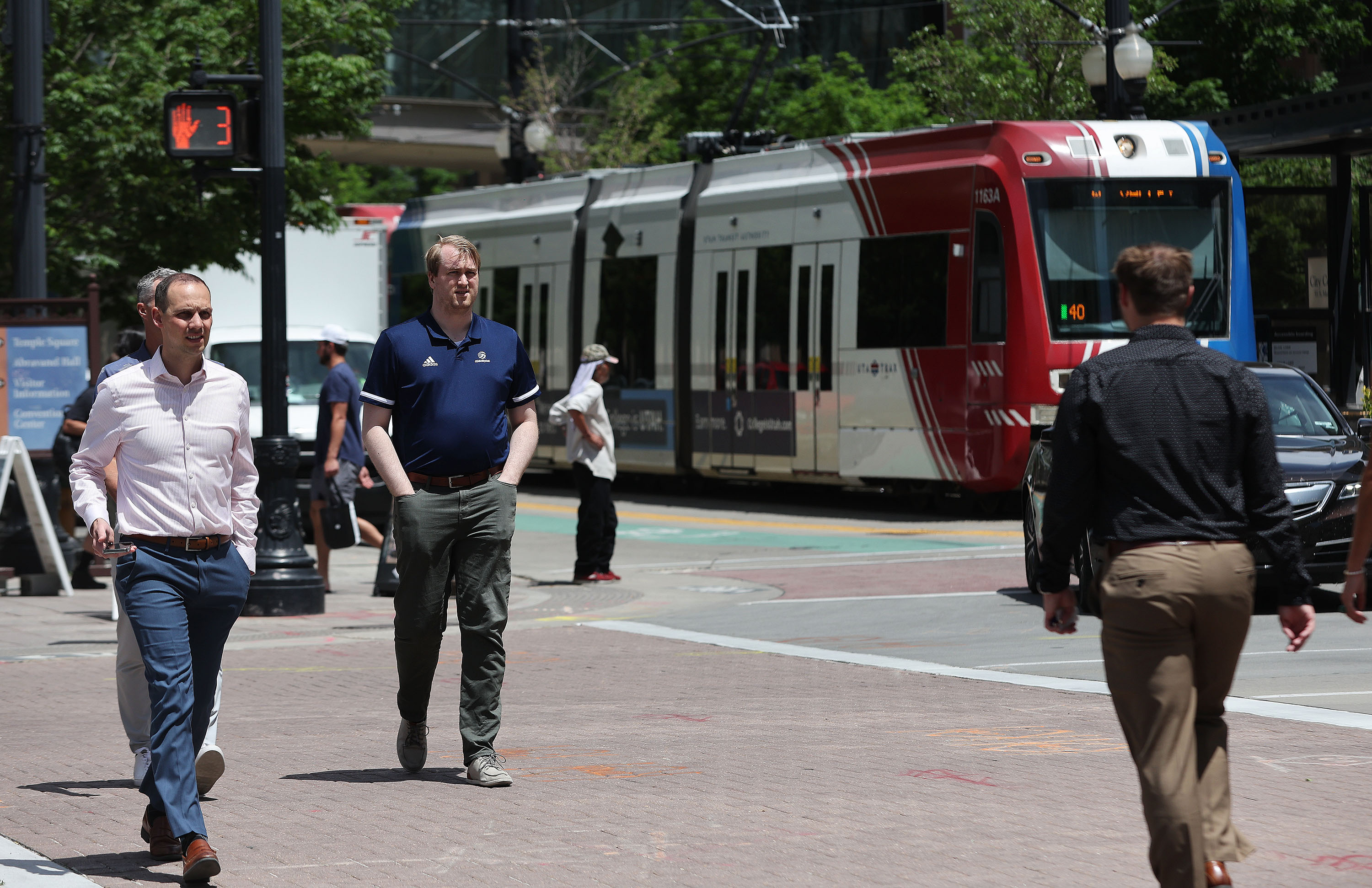 Pedestrians walk on Main Street as a TRAX train goes by in Salt Lake City on May 31, 2023. The city's Open Streets event returns this month with two weekends on Main Street, and the city also plans to test the concept in another area for the first time later this year.