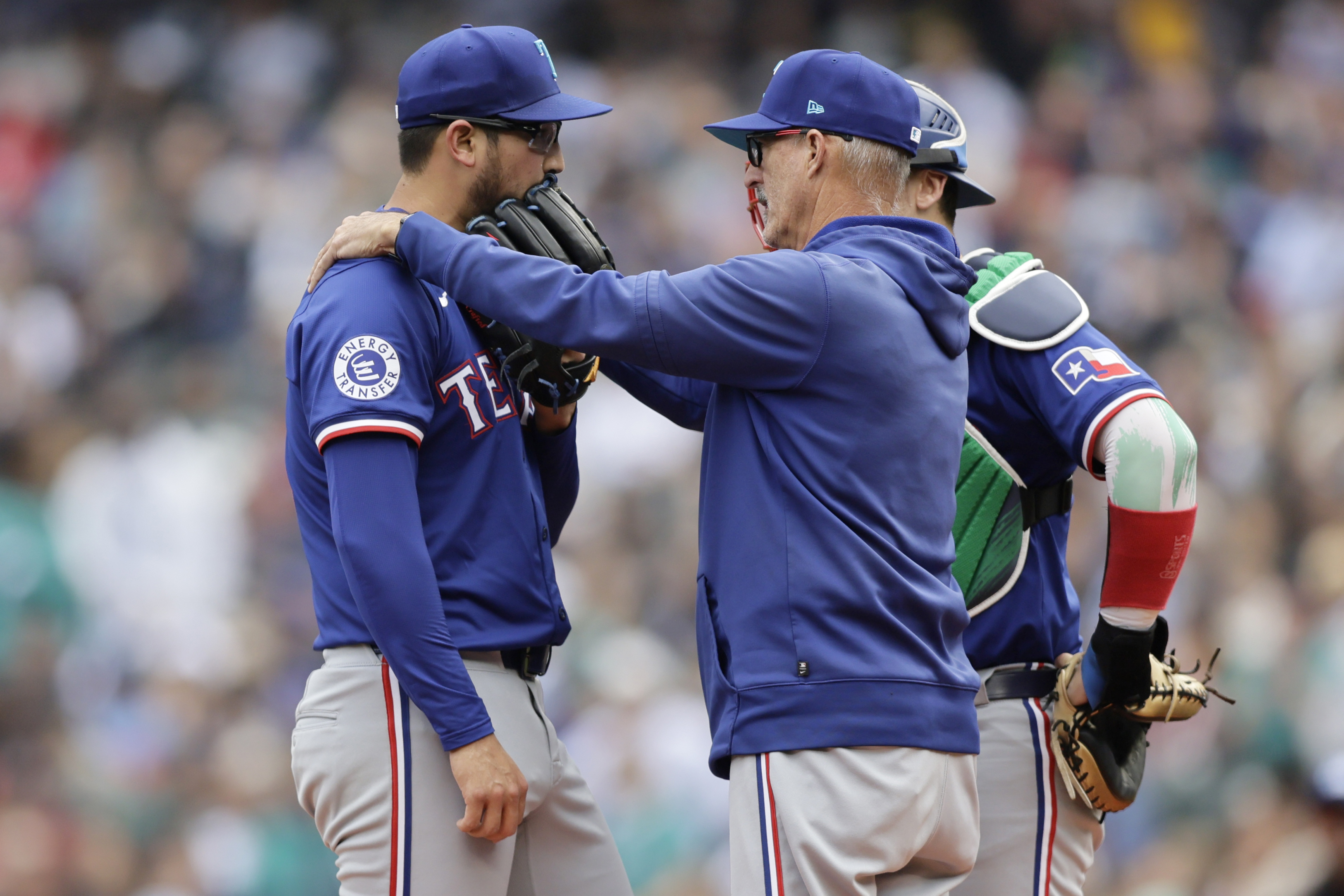 Texas Rangers pitching coach Mike Maddux, front right, talks with starting pitcher Dane Dunning, left, as catcher Andrew Knizner, back right, looks on during the first inning of a baseball game against the Seattle Mariners, Sunday, June 16, 2024, in Seattle.