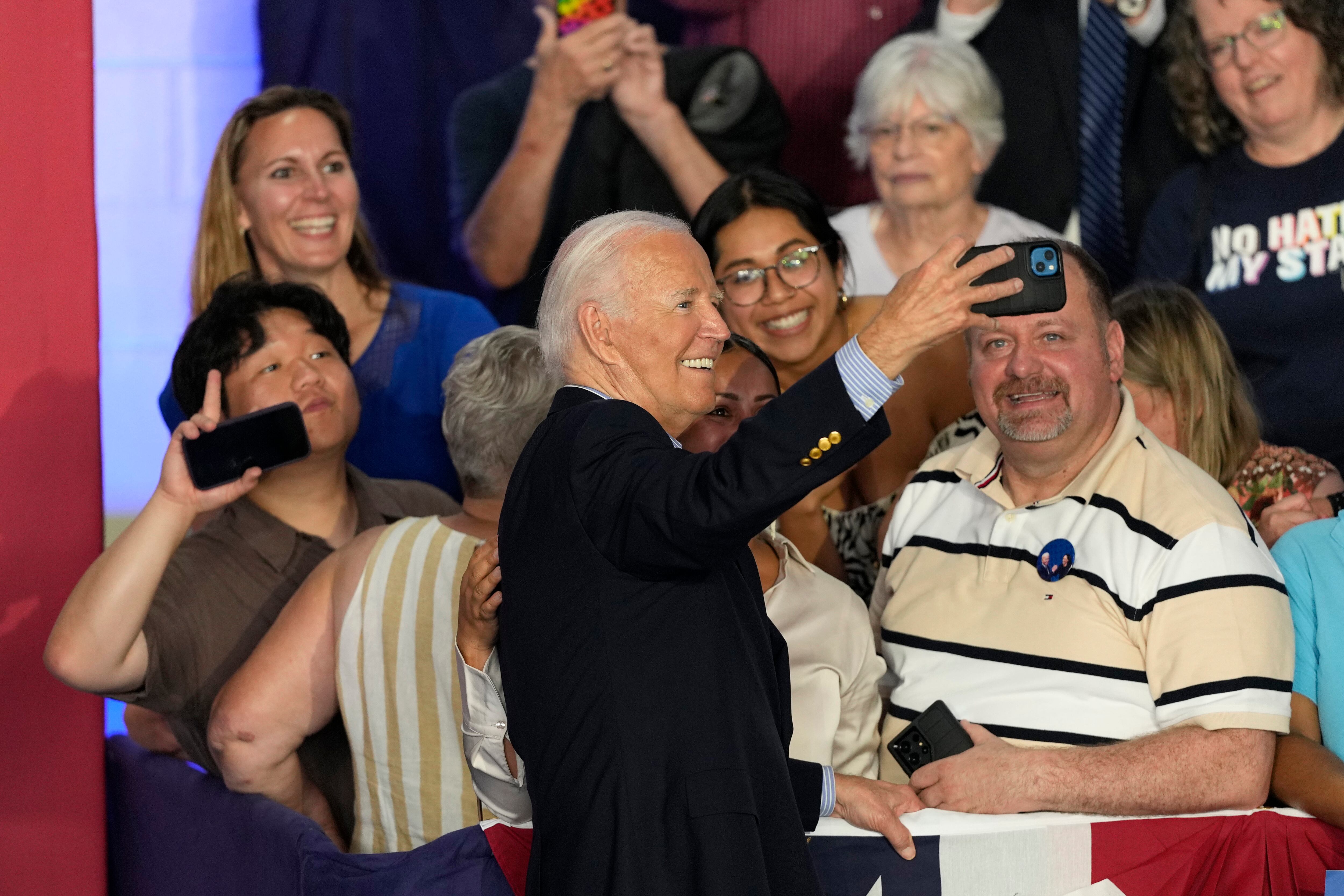 President Joe Biden takes a photo with supporters after speaking at a campaign rally at Sherman Middle School in Madison, Wis., Friday. "I’m staying in this race," a defiant President Joe Biden declared in Wisconsin as he works to repair image.
