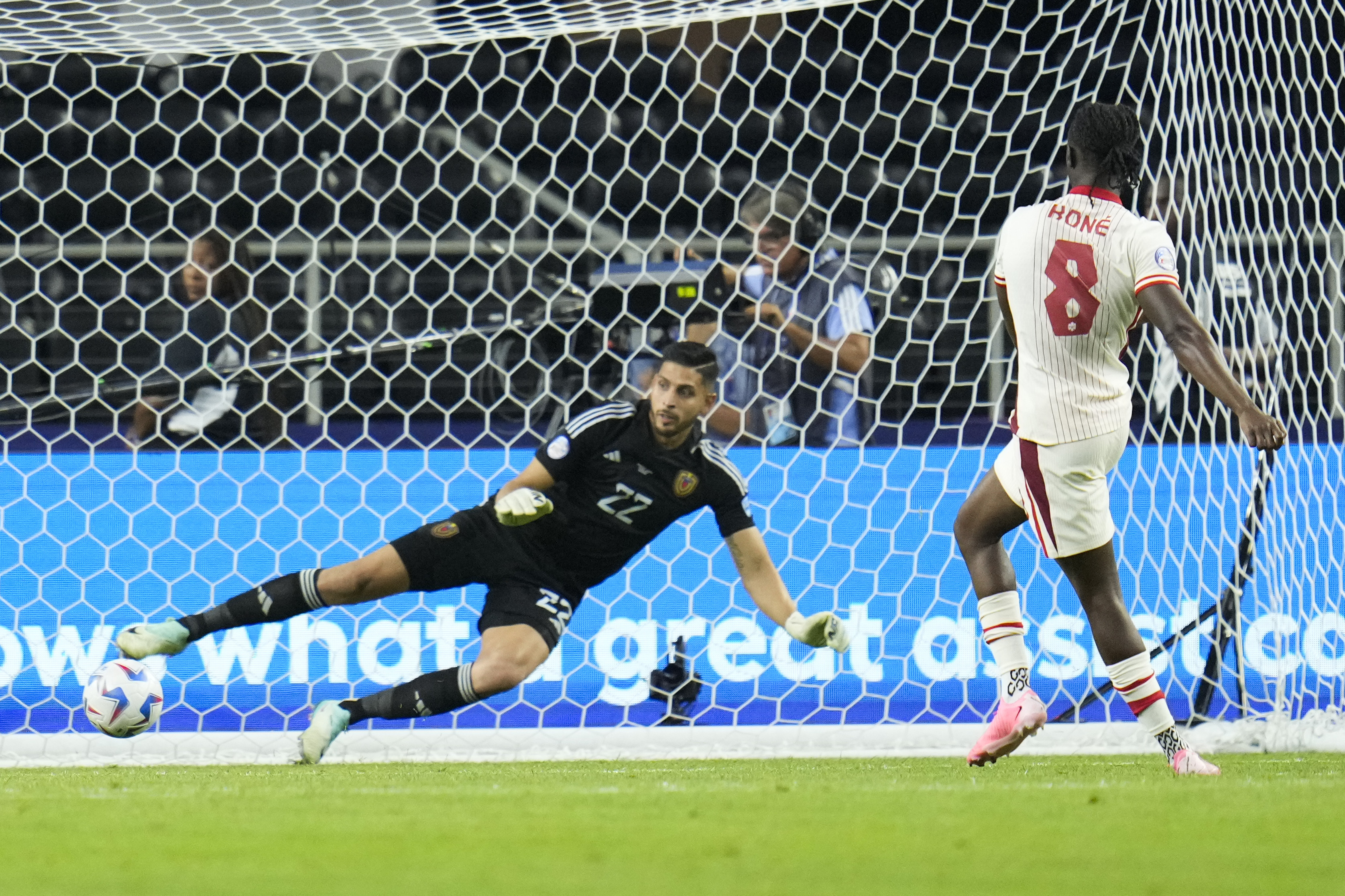 Canada's Ismaël Kenneth Jordan Koné (8) scores against Canada goalkeeper Richard Laryea in a shootout to win a Copa America quarterfinal soccer match between Venezuela and Canada, Friday, July 5, 2024, in Arlington, Texas. 