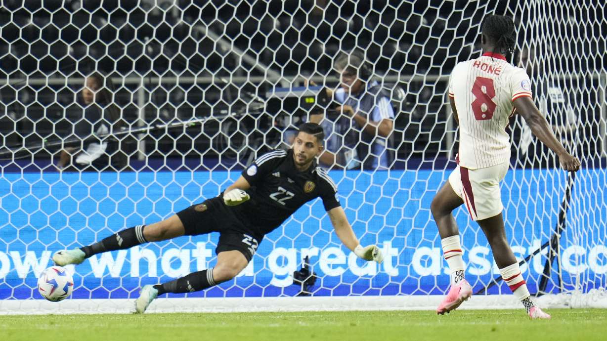 Canada's Ismaël Kenneth Jordan Koné (8) scores against Canada goalkeeper Richard Laryea in a shootout to win a Copa America quarterfinal soccer match between Venezuela and Canada, Friday, July 5, 2024, in Arlington, Texas.