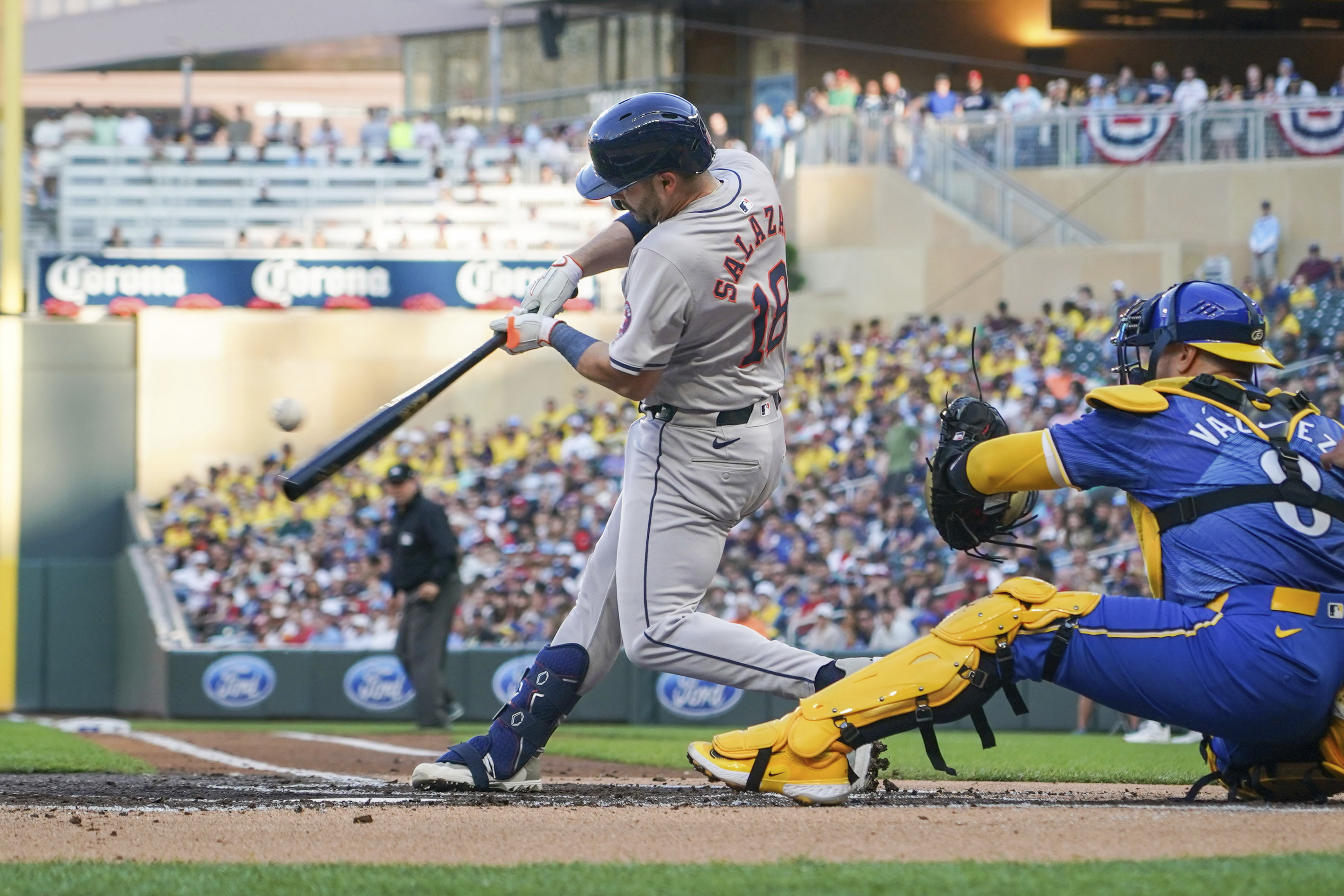 Houston Astros' Cesar Salazar (18) hits an RBI single, scoring Jonathan Singleton, as Minnesota Twins catcher Christian Vazquez (8) looks on during the second inning of a baseball game Friday, July 5, 2024, in Minneapolis.