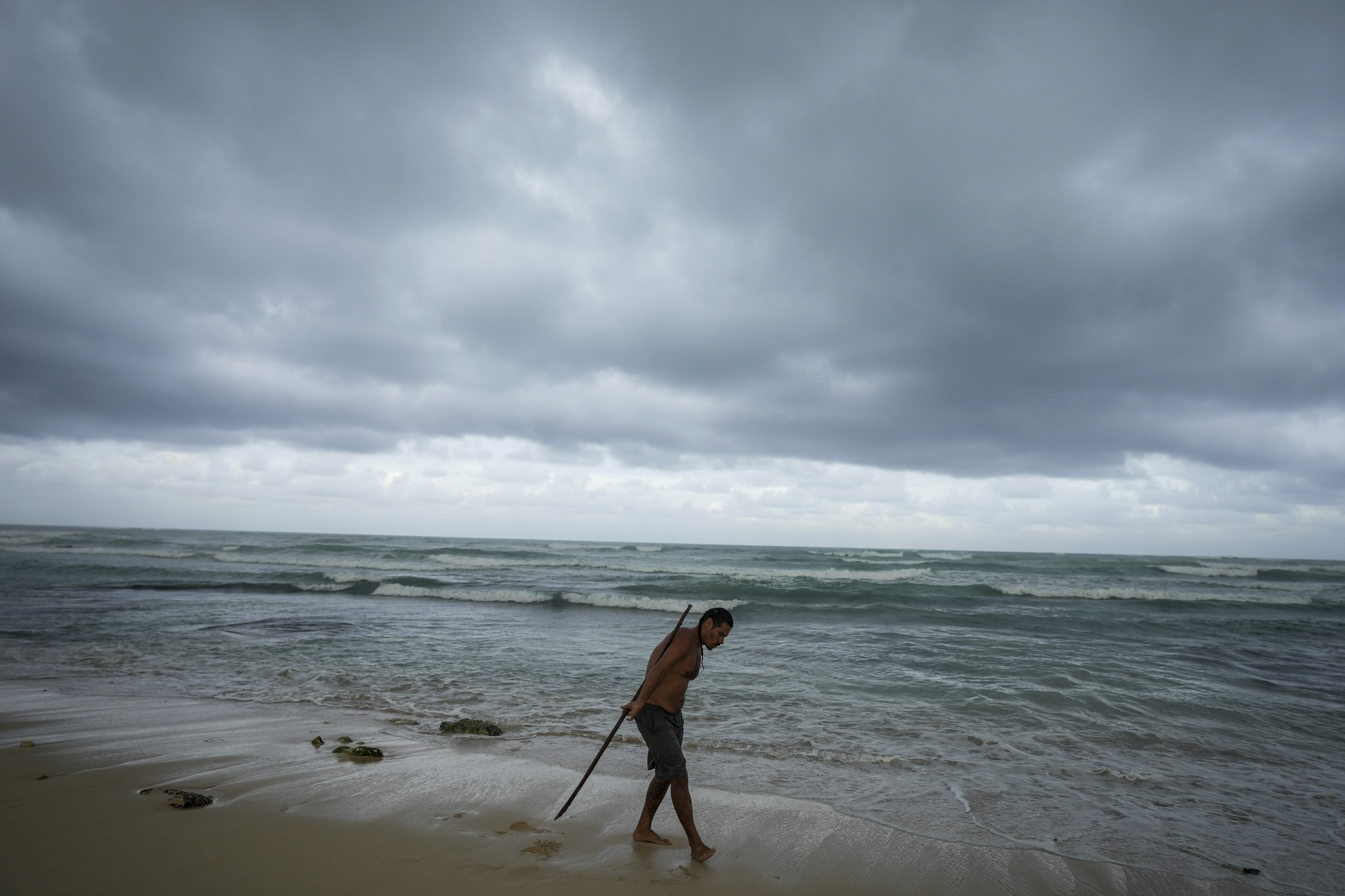 A man practices acrobatics with a pole on the beach in the aftermath by Hurricane Beryl in Tulum, Mexico, Friday.