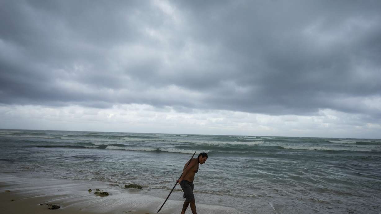 A man practices acrobatics with a pole on the beach in the aftermath by Hurricane Beryl in Tulum, Mexico, Friday.