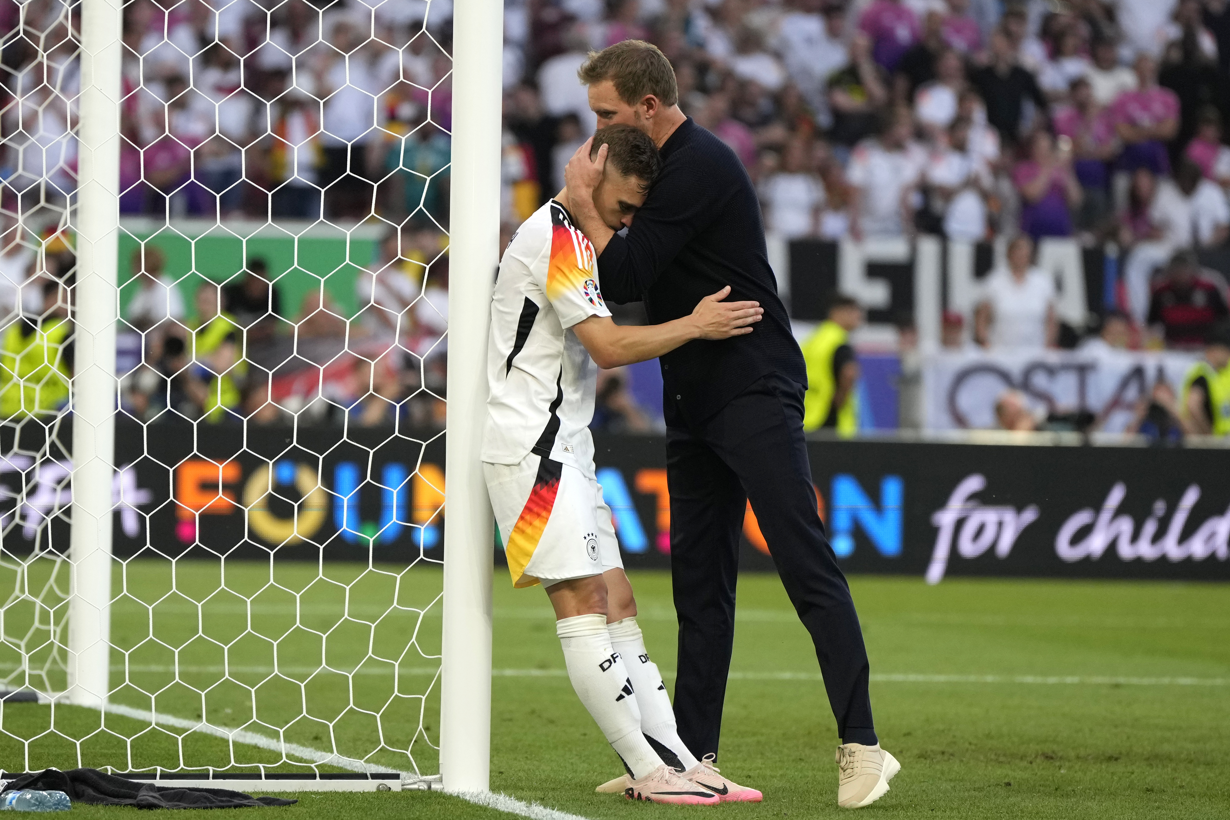 Germany's Joshua Kimmich is hugged by Germany's head coach Julian Nagelsmann at the end of a quarter final match between Germany and Spain at the Euro 2024 soccer tournament in Stuttgart, Germany, Friday, July 5, 2024.