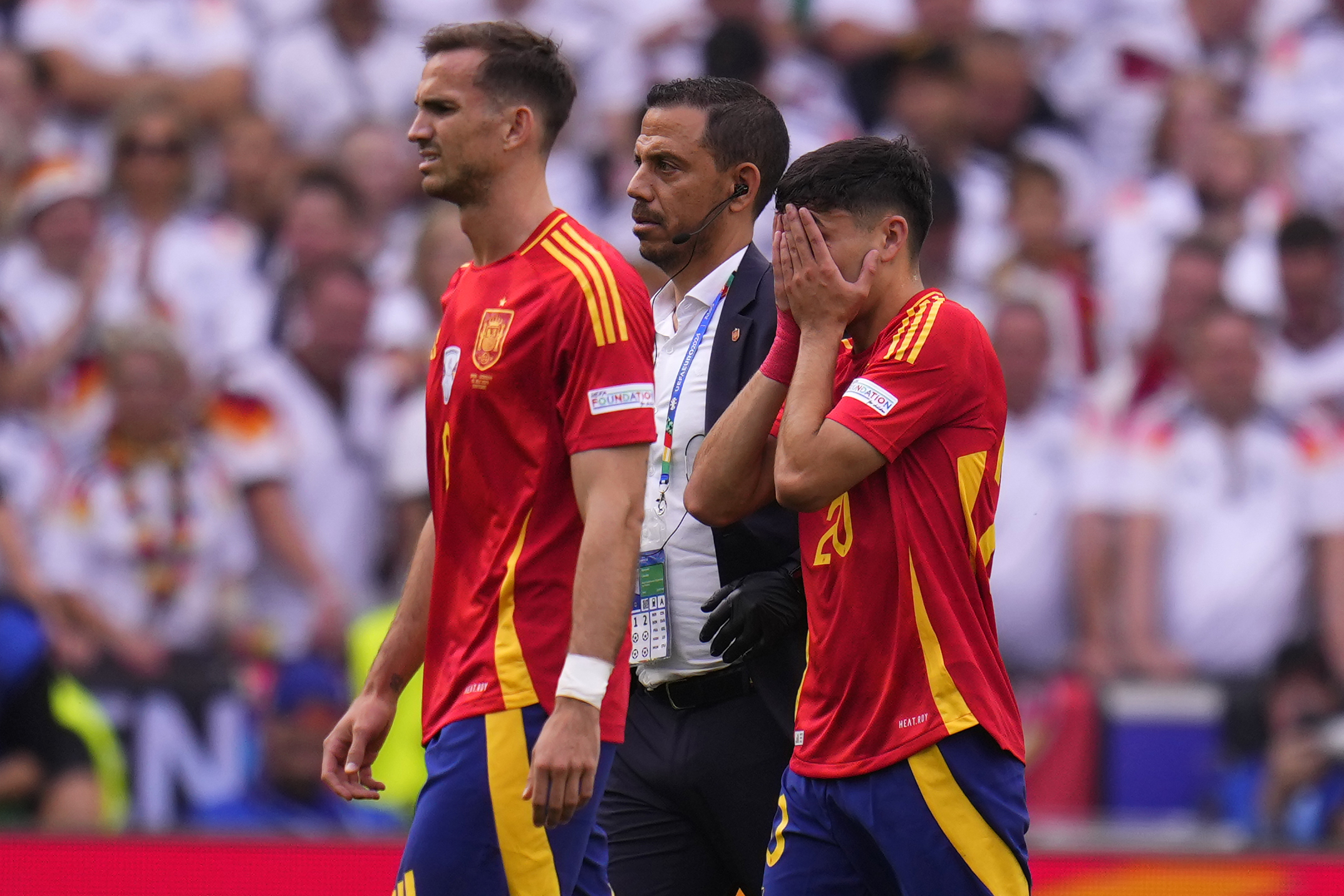Spain's Pedri, right, covers his face after suffering an injury during a quarter final match between Germany and Spain at the Euro 2024 soccer tournament in Stuttgart, Germany, Friday, July 5, 2024. 