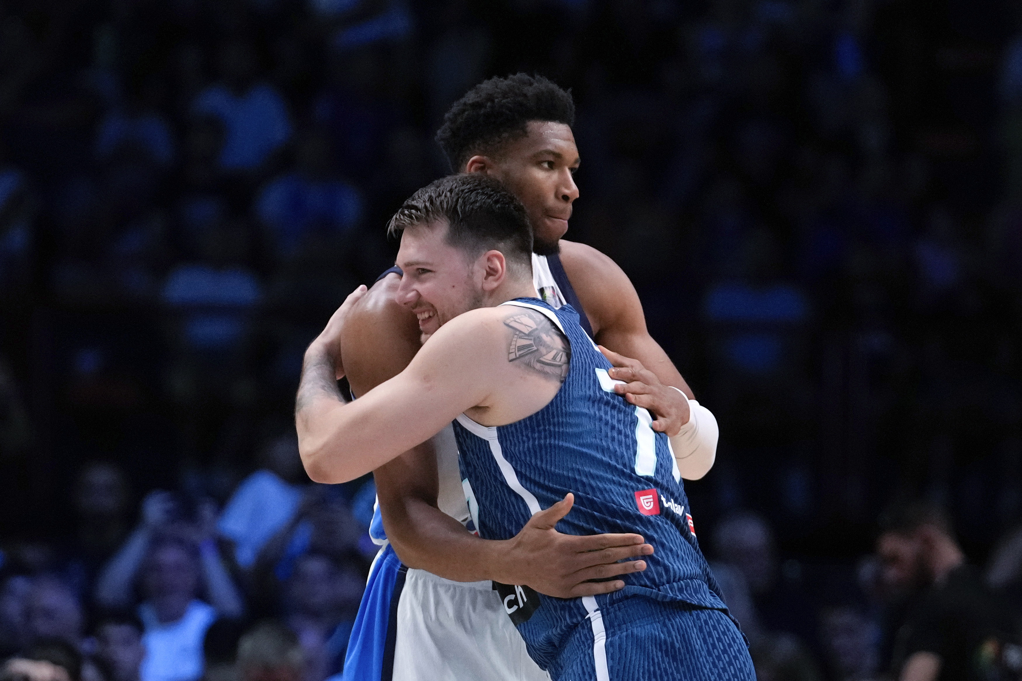 Greece's Giannis Antetokounmpo, rear, hugs Slovenia's Luka Doncic ahead of a basketball match, during the Acropolis basketball tournament at the Peace and Friendship indoor stadium at Athens' port city of Piraeus, Saturday, July 6, 2024. 