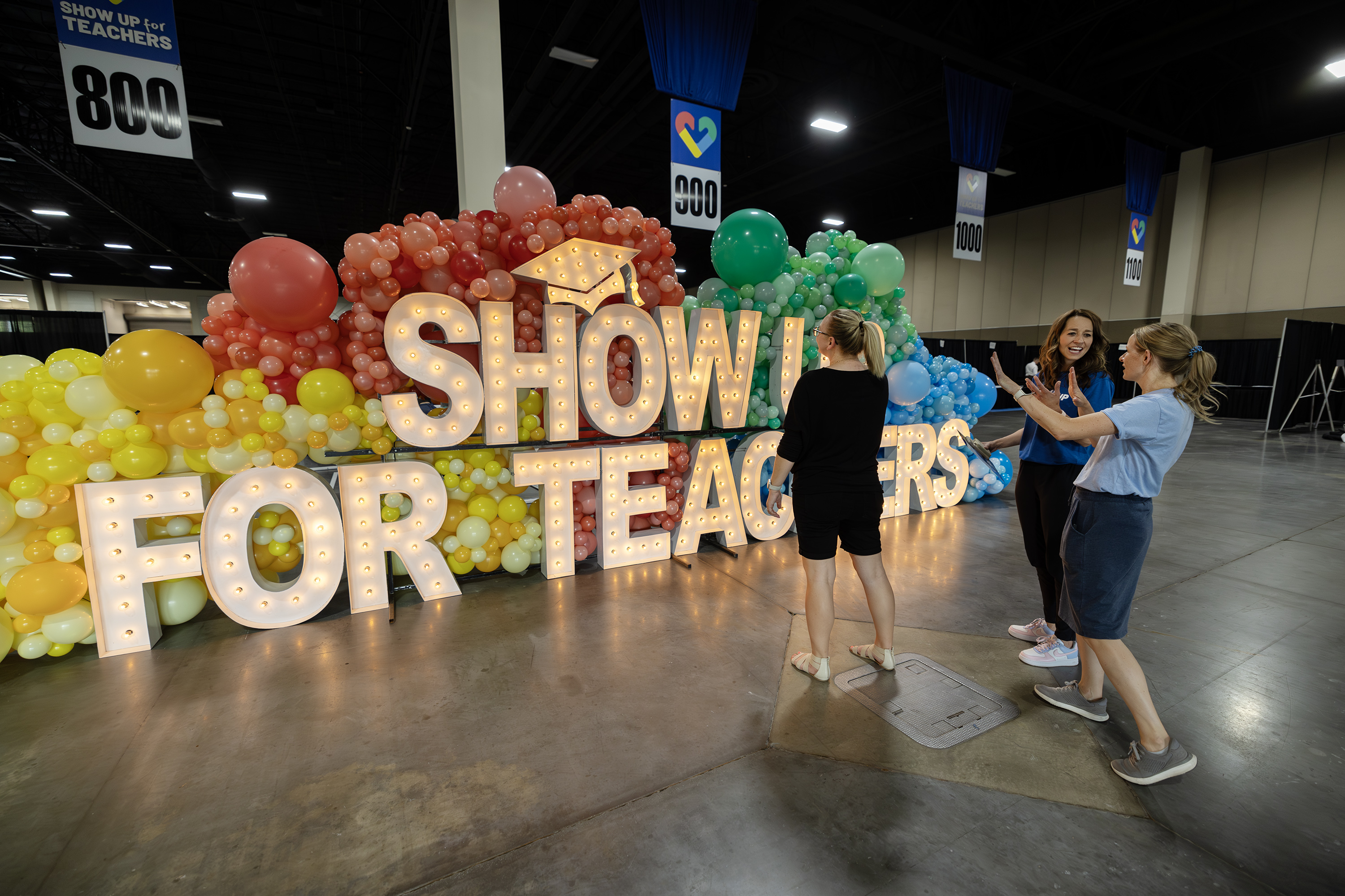 Utah First Lady Abby Cox, Director of First Lady Initiatives Kirsten Rappleye and Deputy Director of the Show Up Initiative Sarah Allred look over the main entrance sign as they work to get ready for the "Show Up for Teachers" event at the Mountain America Exhibition Center in Sandy on Tuesday, July 18, 2023.