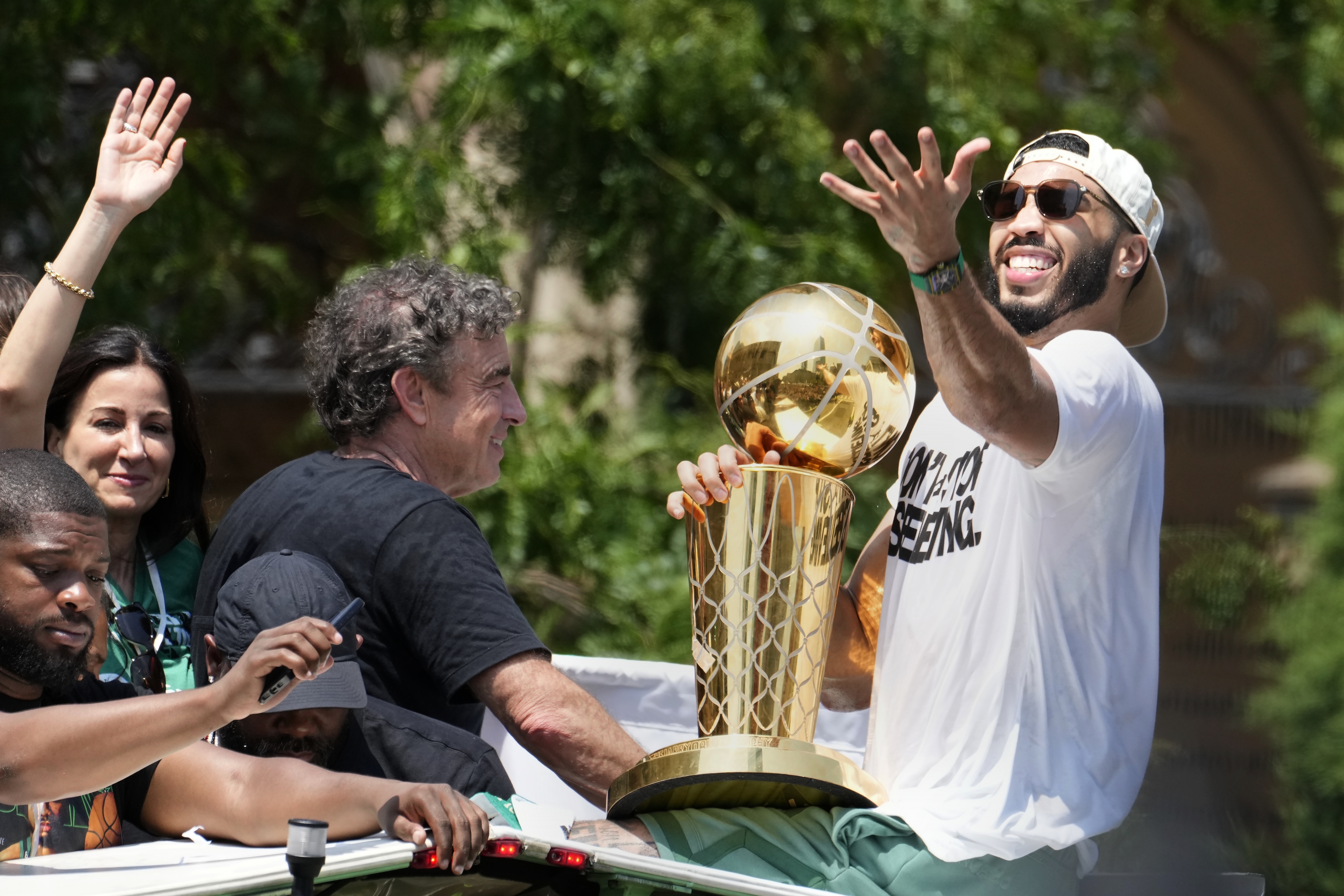 Boston Celtics' Jayson Tatum, right, and Celtics owner Wyc Grousbeck, center, celebrate their NBA basketball championship with a duck boat parade Friday, June 21, 2024, in Boston. 