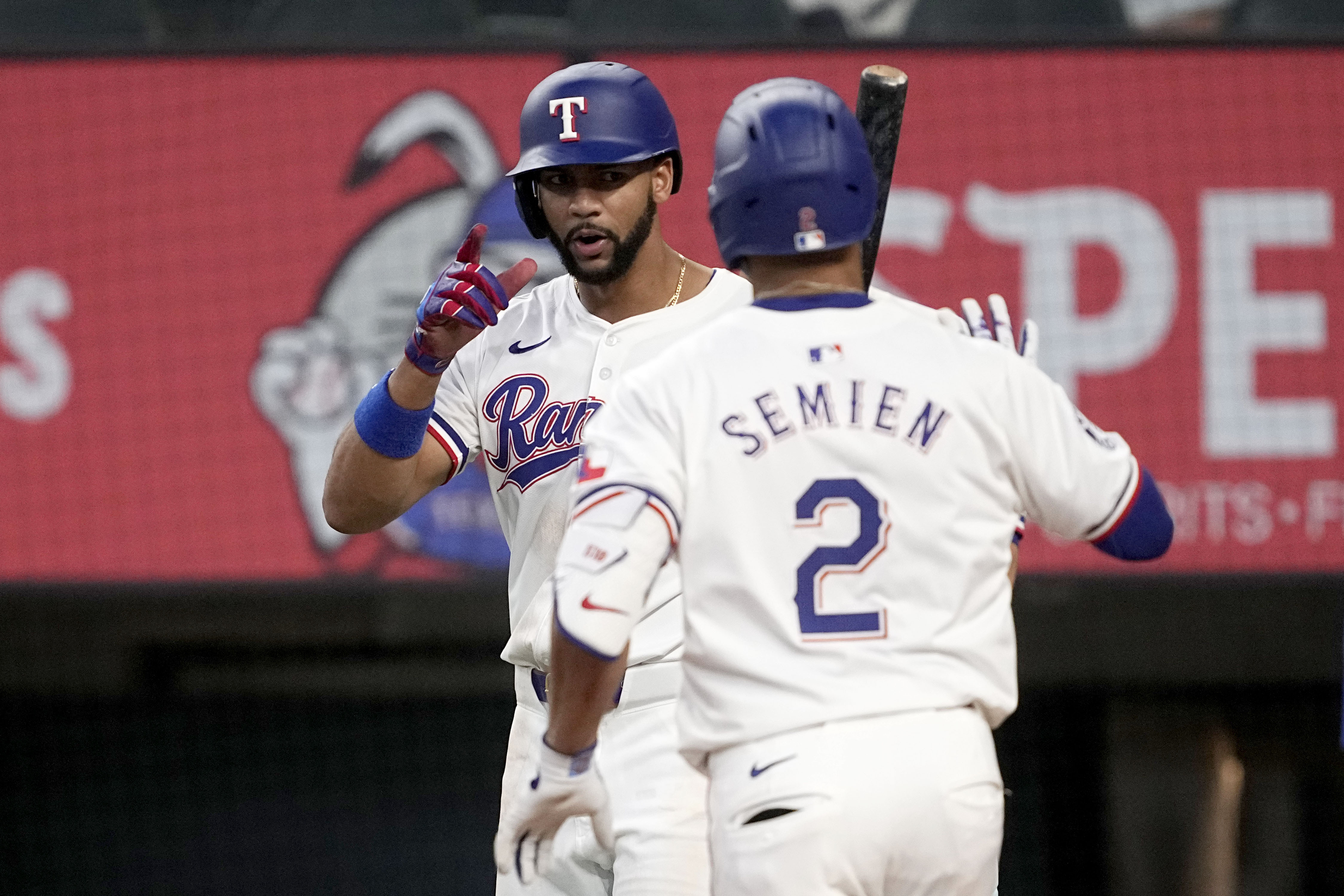 Texas Rangers' Leody Taveras, left, and Marcus Semien (2) celebrate after Semien hit a two-run home run that also scored Taveras against the Tampa Bay Rays in the seventh inning of a baseball game in Arlington, Texas, Saturday, July 6, 2024. 
