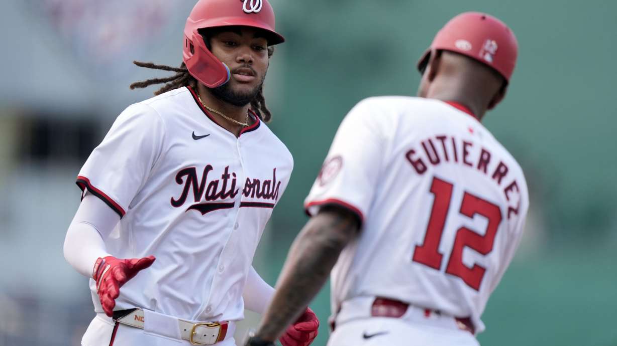 Washington Nationals' James Wood, left, is congratulated by third base coach Ricky Gutierrez after hitting a three-run home run during the second inning of a baseball game against the St. Louis Cardinals at Nationals Park, Saturday, July 6, 2024, in Washington.