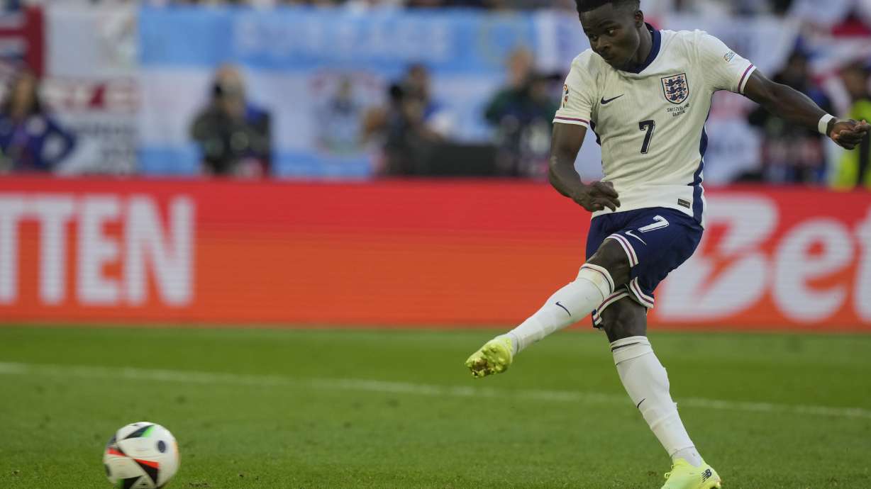 England's Bukayo Saka scores during the penalty shootout of a quarterfinal match between England and Switzerland at the Euro 2024 soccer tournament in Duesseldorf, Germany, Saturday, July 6, 2024.