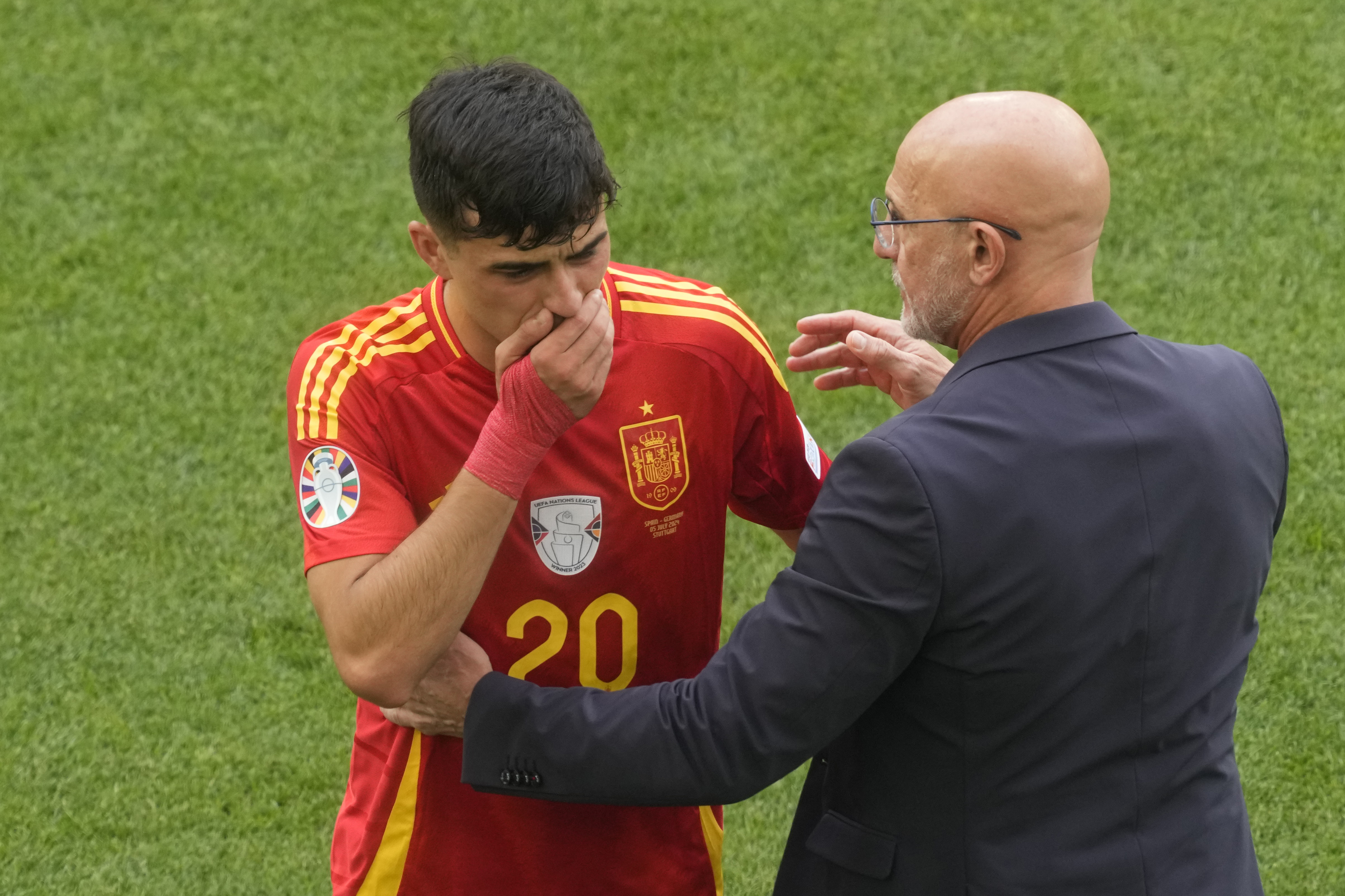 Spain's head coach Luis de la Fuente, right, shows concern for Spain's Pedri after he got hurt during a quarter final match between Germany and Spain at the Euro 2024 soccer tournament in Stuttgart, Germany, Friday, July 5, 2024.