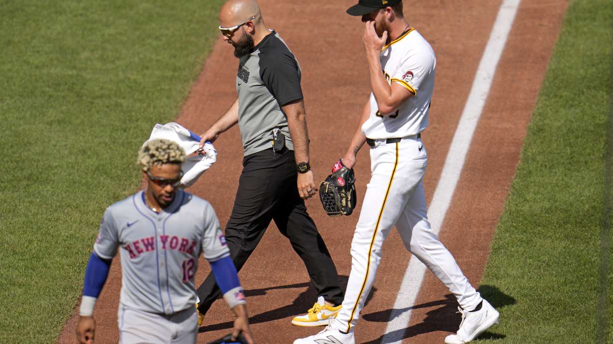 Pittsburgh Pirates starting pitcher Bailey Falter, right, walks to the dugout with a team trainer after removing himself in the third inning of a baseball game against the New York Mets in Pittsburgh, Saturday, July 6, 2024.