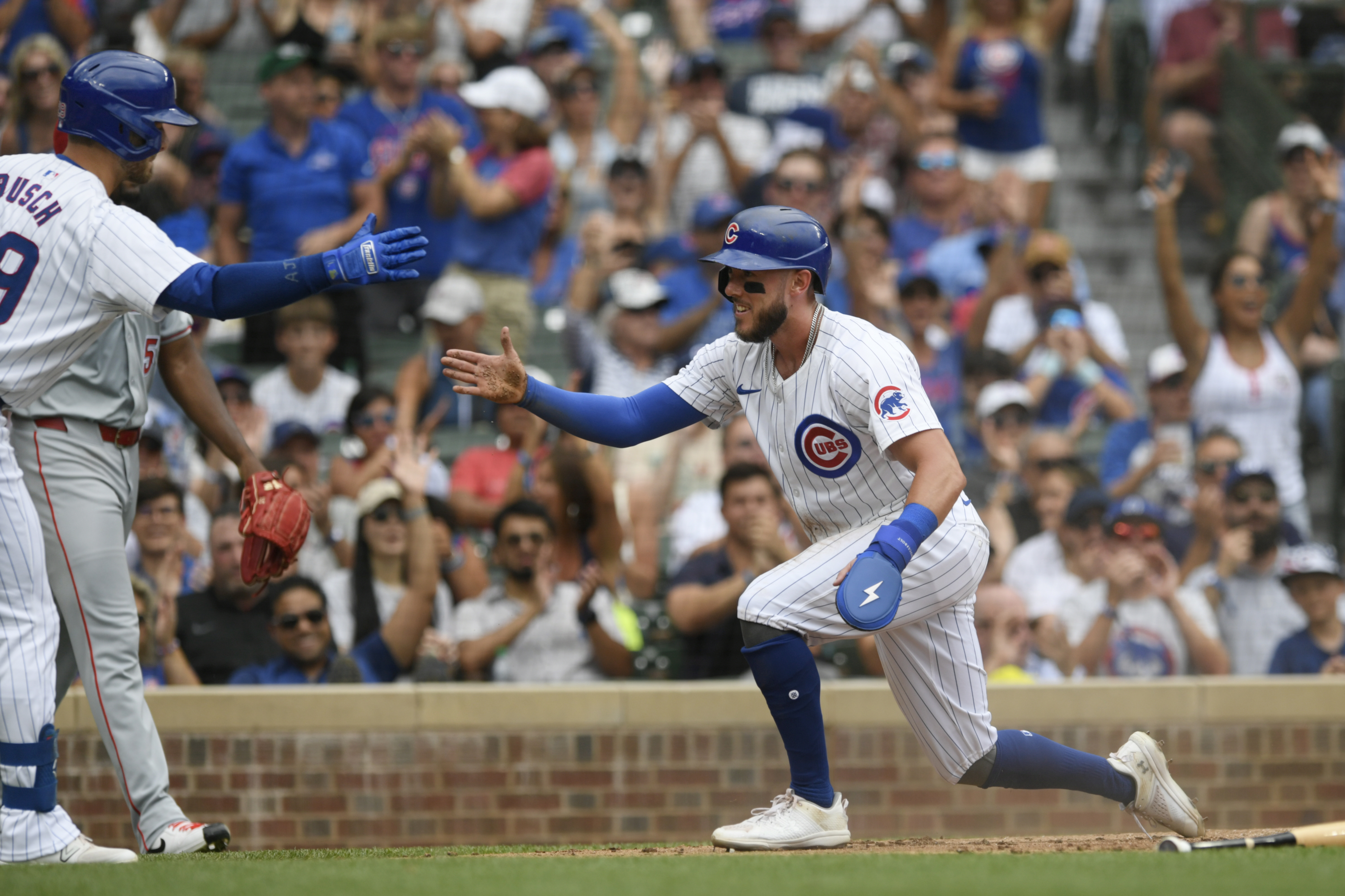 Chicago Cubs' Miles Mastrobuoni, right, celebrates with teammate Michael Busch, left, at home plate after scoring on a Nico Hoerner sacrifice fly during the third inning of a baseball game against the Los Angeles Angels, Sunday, July 7, 2024, in Chicago.