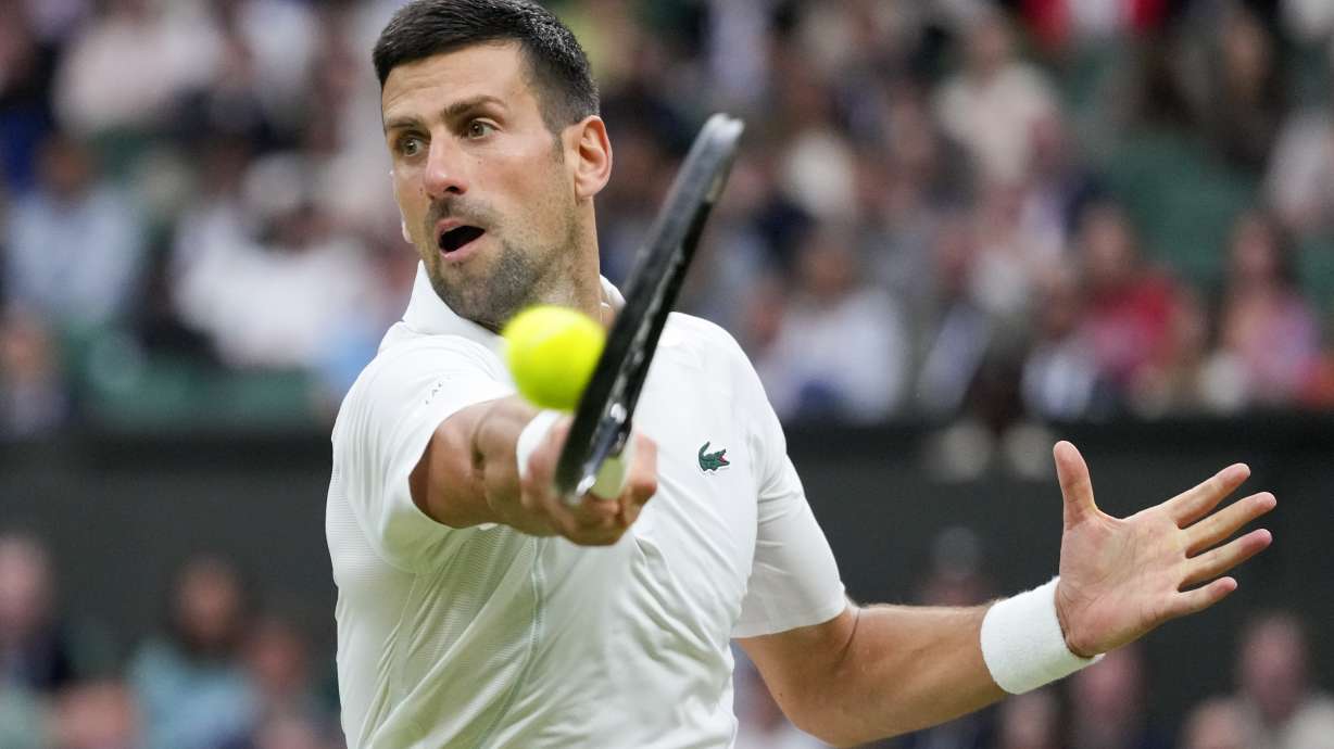 Novak Djokovic of Serbia plays a backhand return to Alexei Popyrin of Australia during their third round match at the Wimbledon tennis championships in London, Saturday, July 6, 2024.