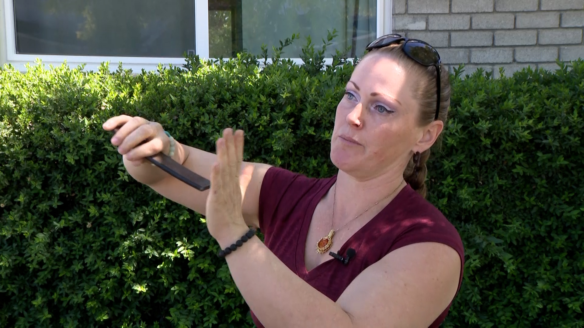 Hope McCurdy uses the metal piece that flew at her car while she was driving on I-15 in Salt Lake County June 21 to describe how it hit her car’s windshield.