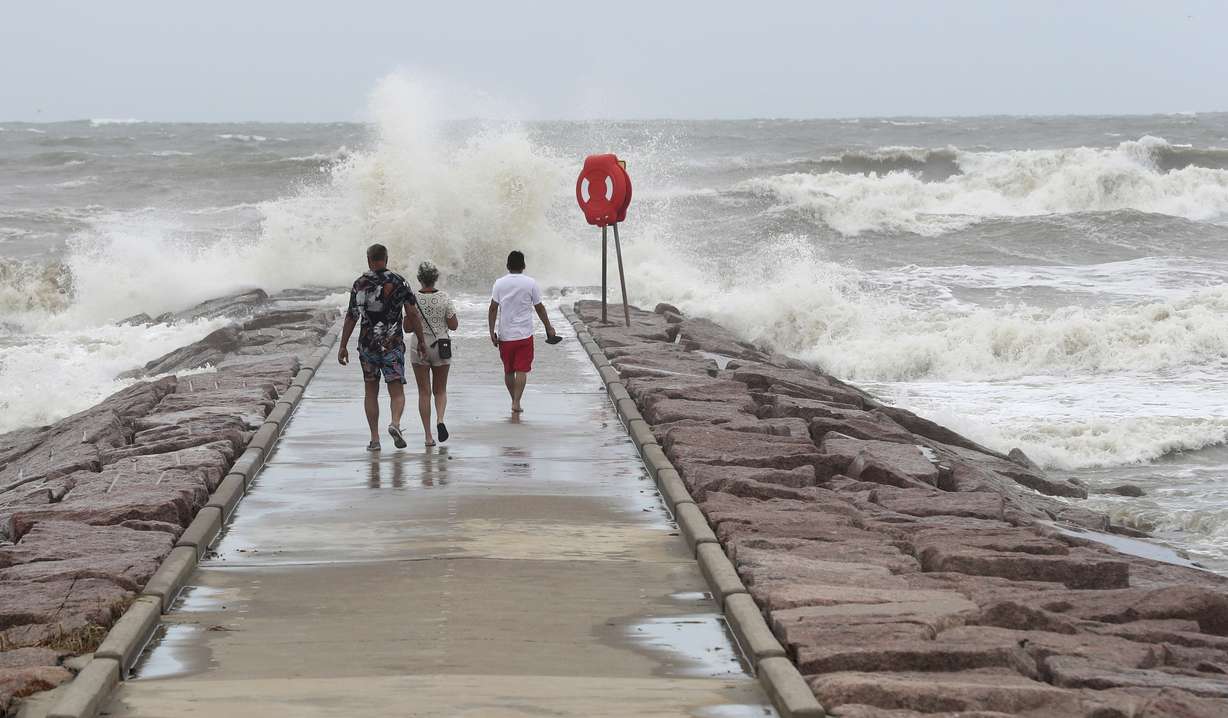 People watch waves crash into the 37th Street rock groin in Galveston, Texas, on Sunday, as Tropical Storm Beryl churned toward the Texas Coast.