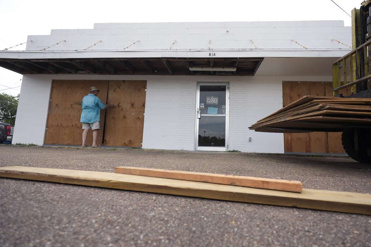Jimmy May boards windows as he prepares for Beryl's arrival, Sunday, in Port Lavaca, Texas.